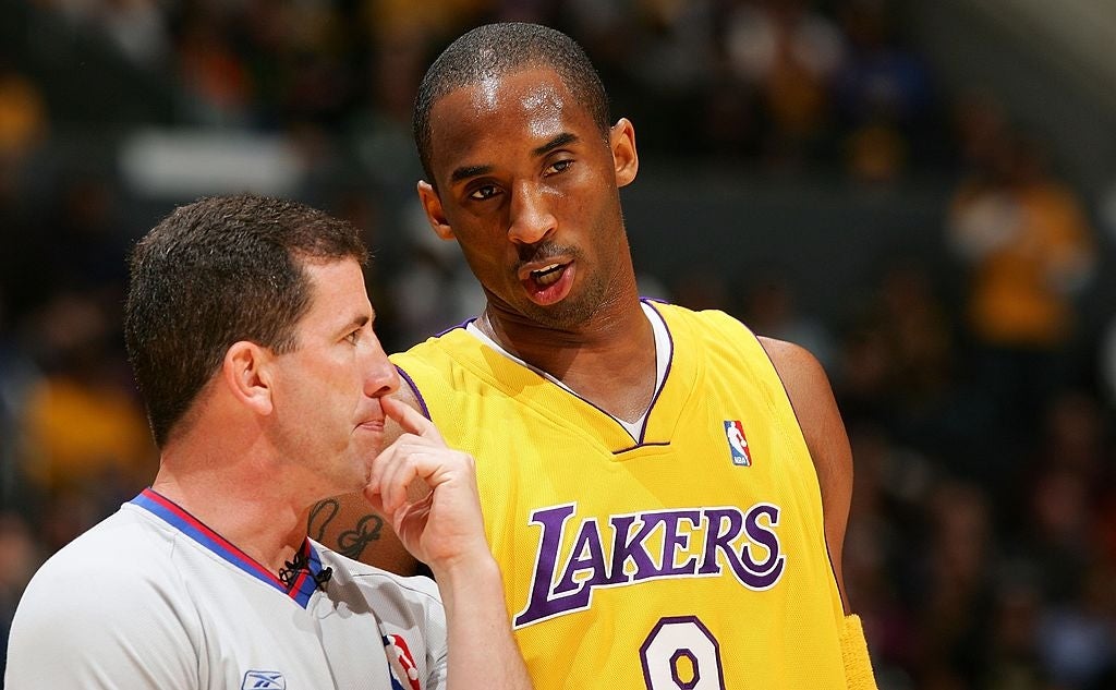 A hoops  subordinate    successful  a Lakers jersey talks to a referee during a game