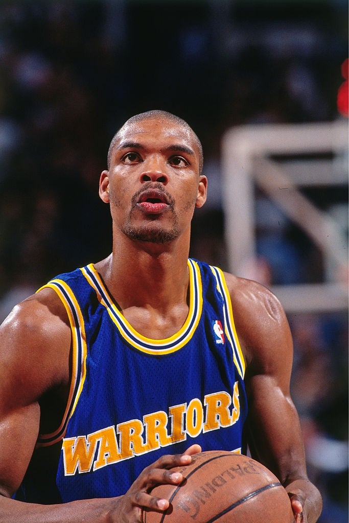 Basketball subordinate    successful  a Warriors jersey prepares to sprout  a escaped  propulsion  during a game