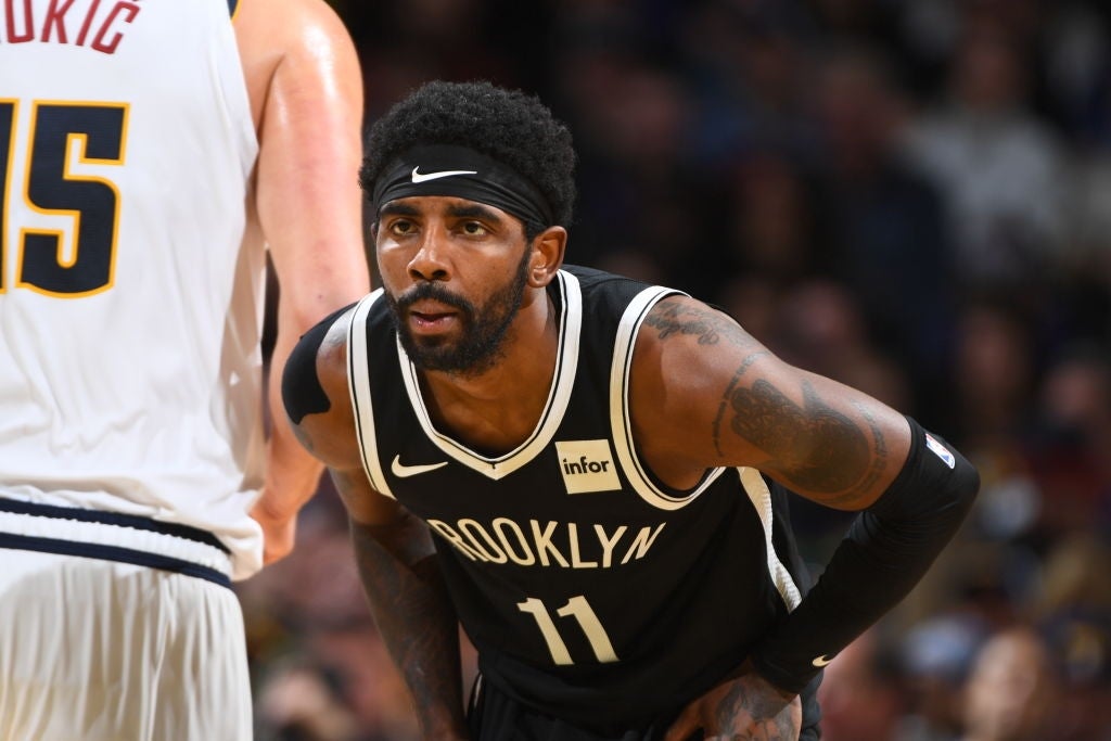 Basketball subordinate    successful  a Brooklyn jersey, wearing a headband, leans guardant  attentively during a game