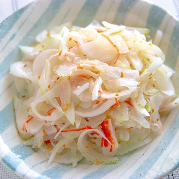 玉ねぎとカニカマの和え物が器に盛られている。 새콤달콤한 양념が 아침식사로 어울린다