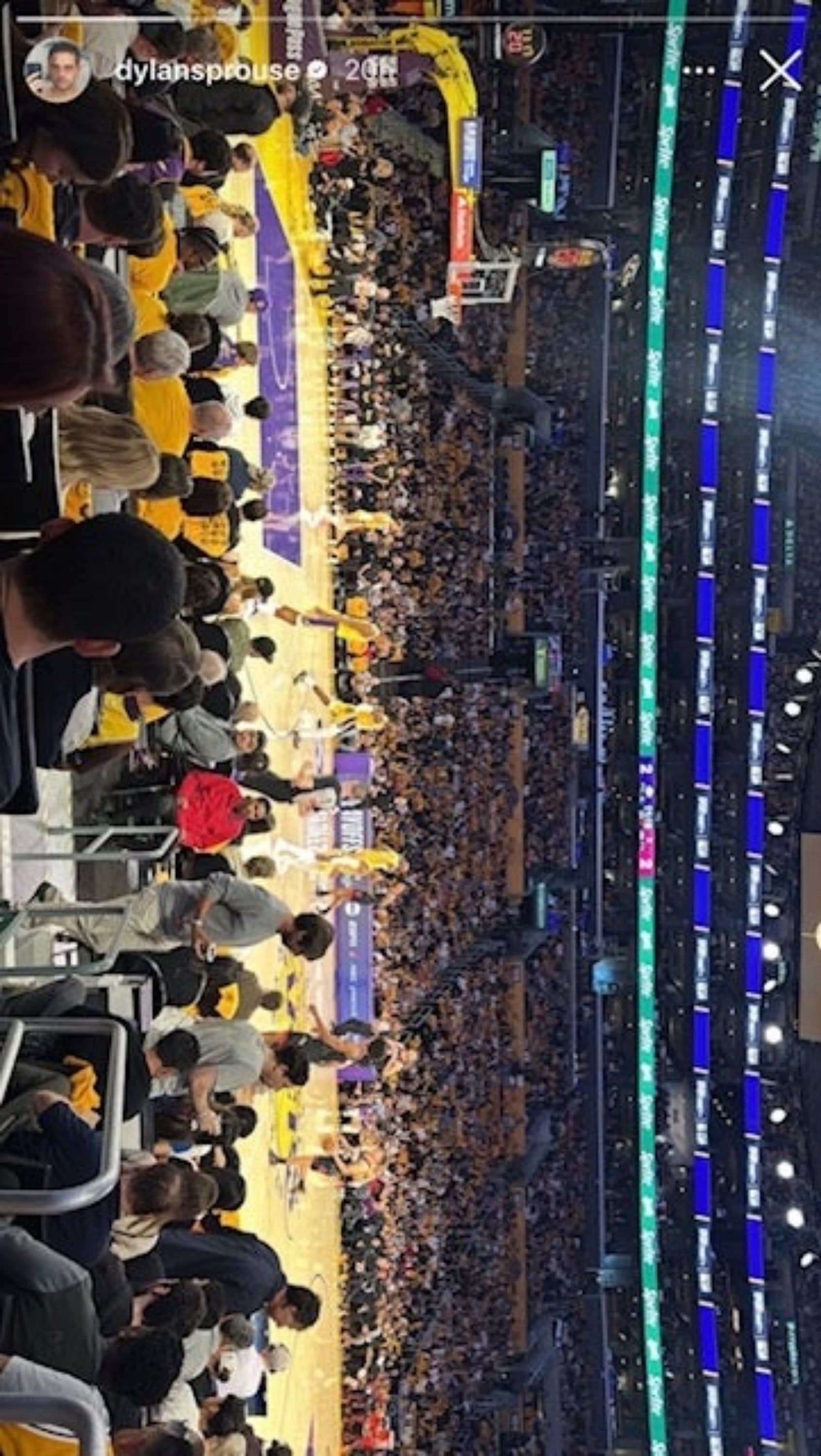 Basketball crippled  successful  a packed stadium, viewed from the stands, with players connected  the tribunal  and assemblage  watching