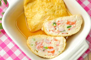 皿の上に盛られたかにかま入り厚焼き卵。ピクニック用テーブルクロスの上に置かれている。