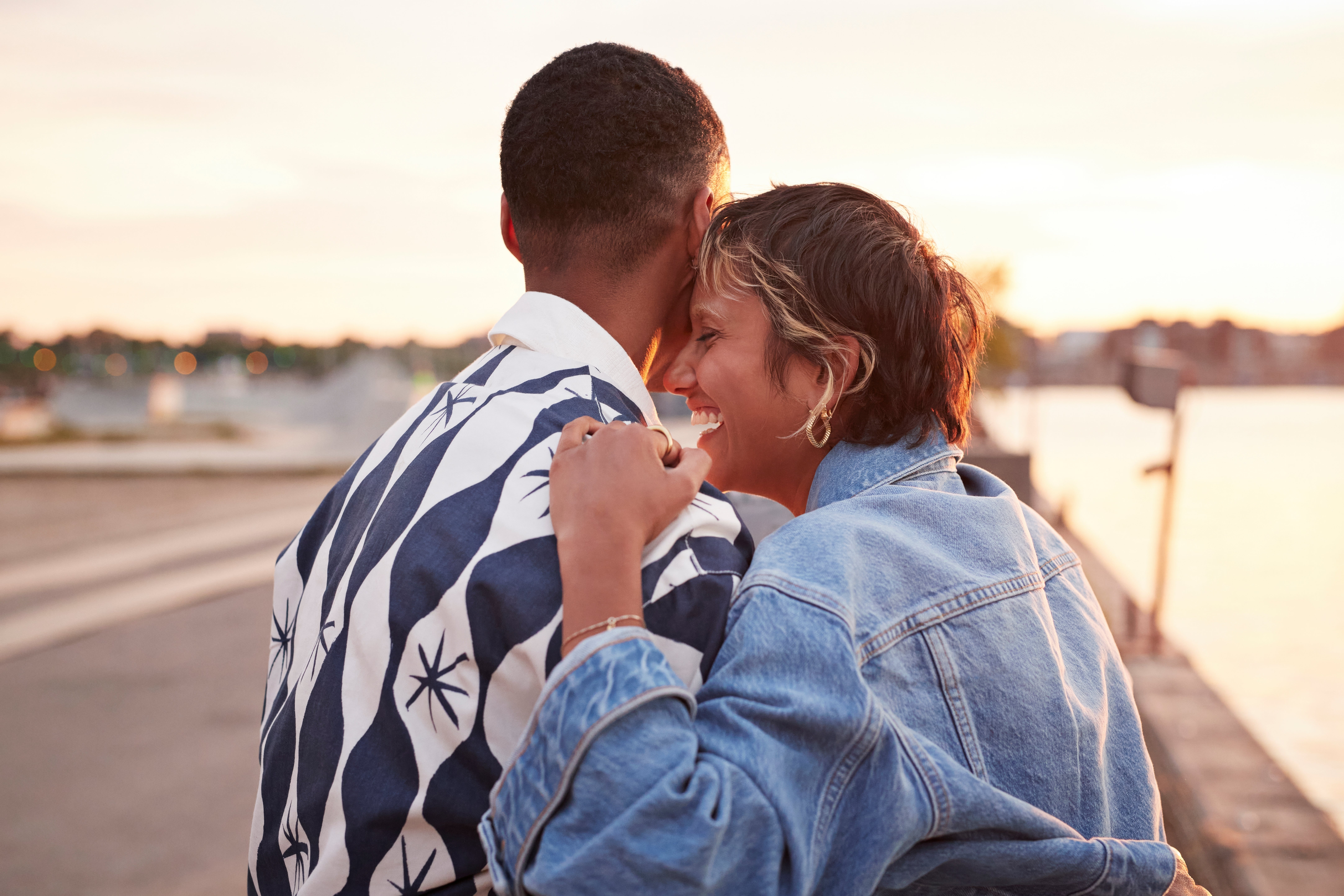 Two people hugging by the water