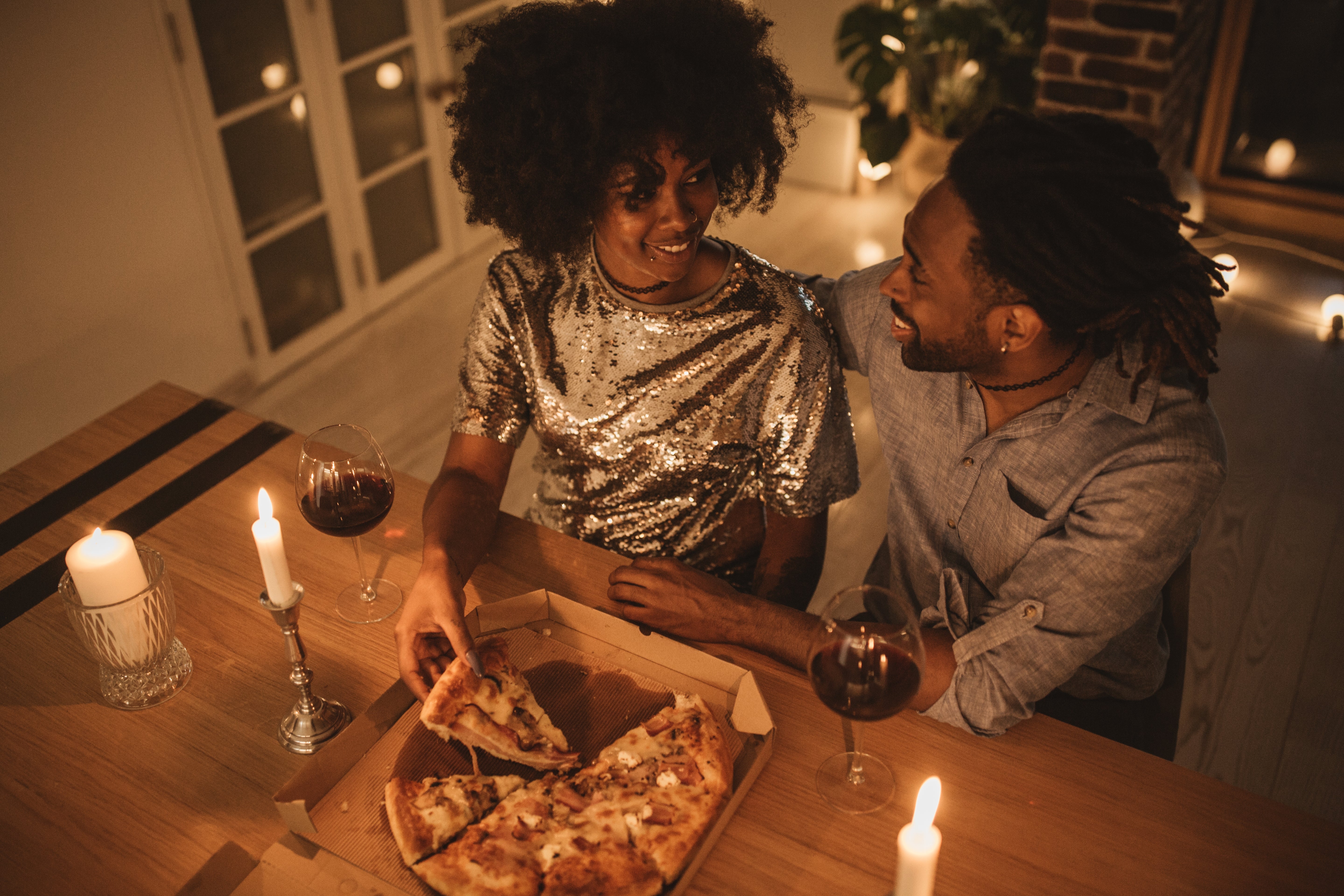A couple eating pizza at home