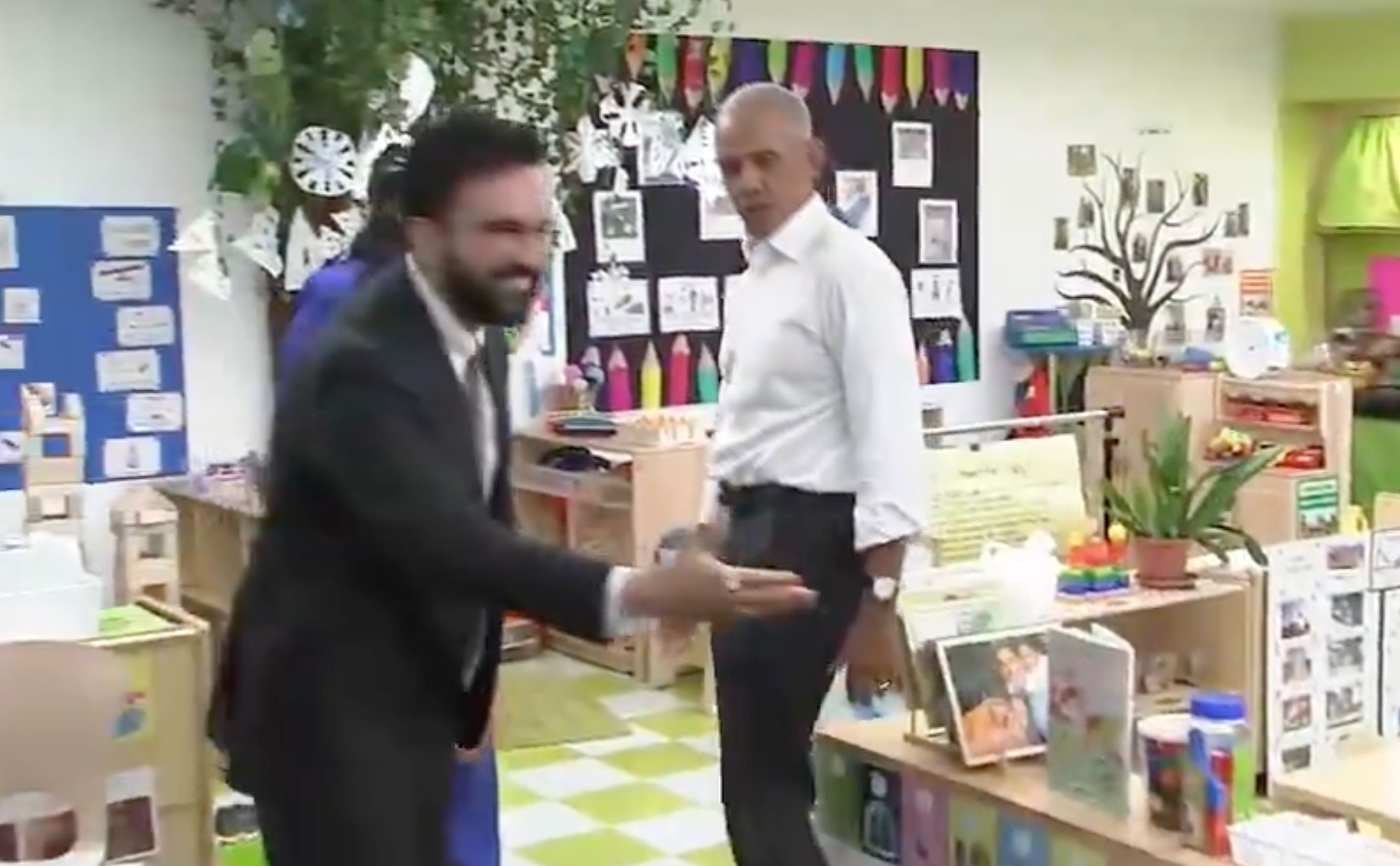 Man successful  a suit   enthusiastically interacts with a erstwhile  U.S. president   successful  a playful, decorated schoolroom  setting