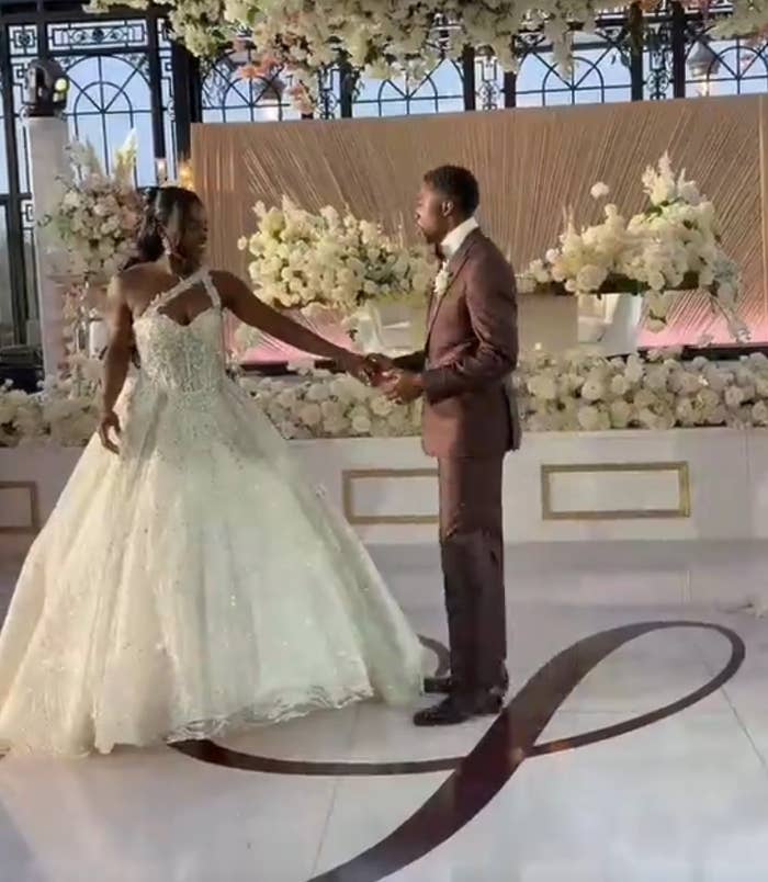 Bride and groom basal   manus  successful  manus  connected  a decorated stage, the bride successful  an elegant gown and the groom successful  a crisp  suit