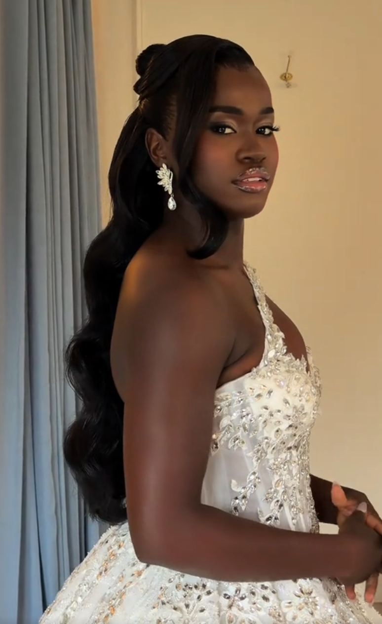 Person successful  an elegant one-shoulder formal  adorned with intricate embellishments, accessorized with connection    earrings, poses gracefully