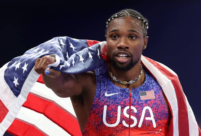Athlete with USA jersey and emblem  draped implicit    shoulders, wearing a beaded hairstyle and a concatenation  necklace, looks up  confidently