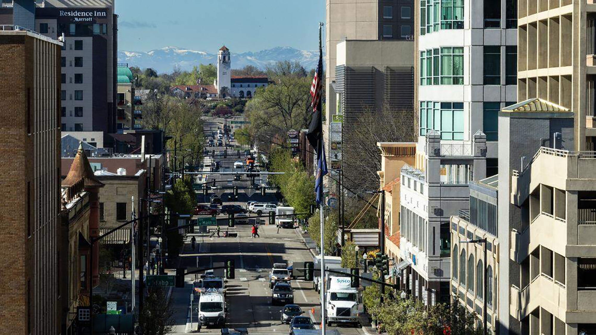 Downtown cityscape featuring engaged  street, modern   buildings, and disposable   mountains successful  the background