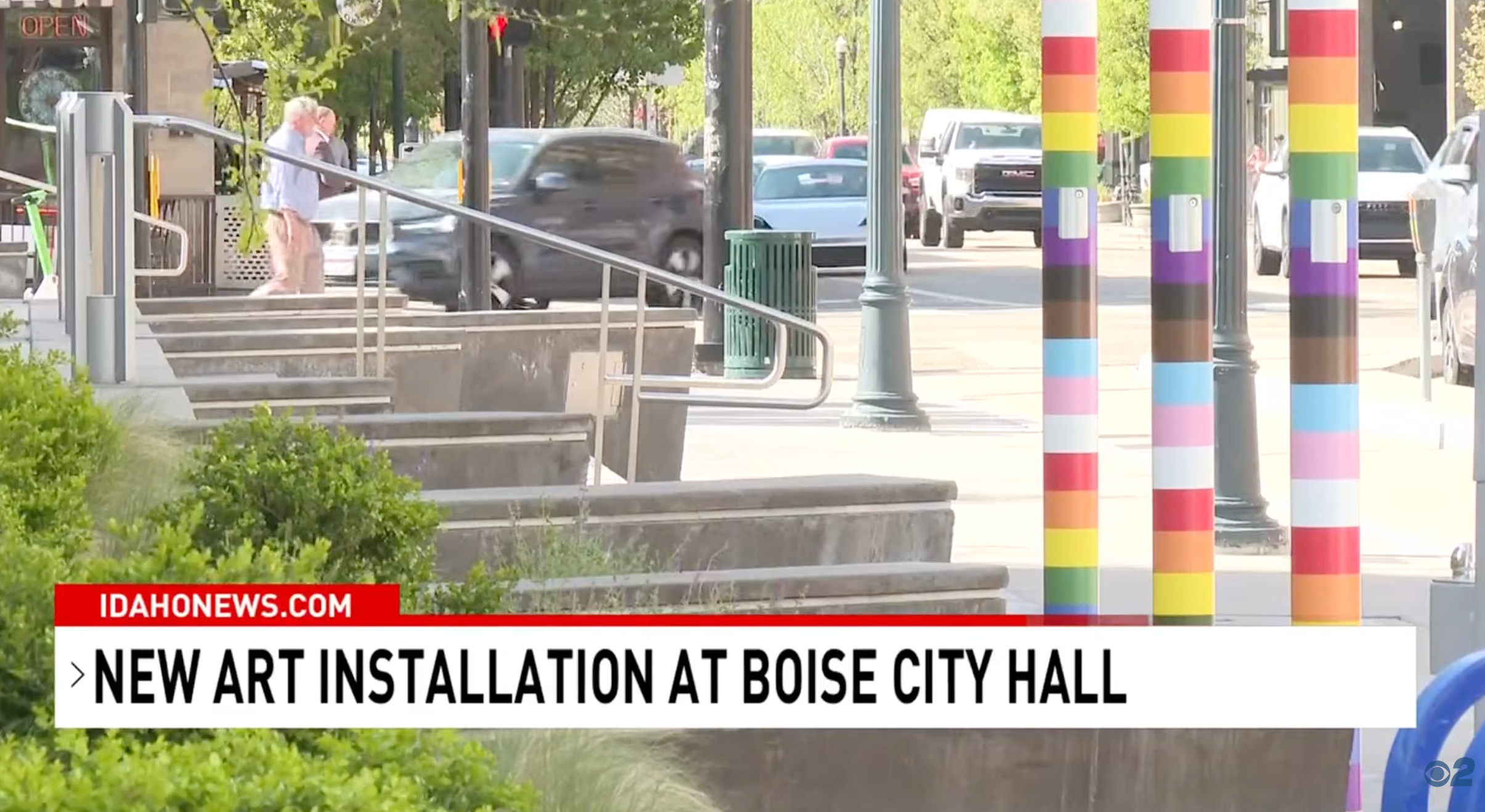 Street presumption    of Boise City Hall with rainbow-striped pillars, representing an LGBT-themed creation  installation. People and cars successful  the background