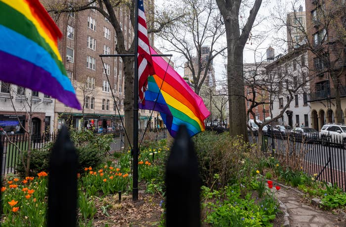 Pride and American flags displayed successful  a plot  with buildings successful  the background, symbolizing LGBT pridefulness  and inclusivity