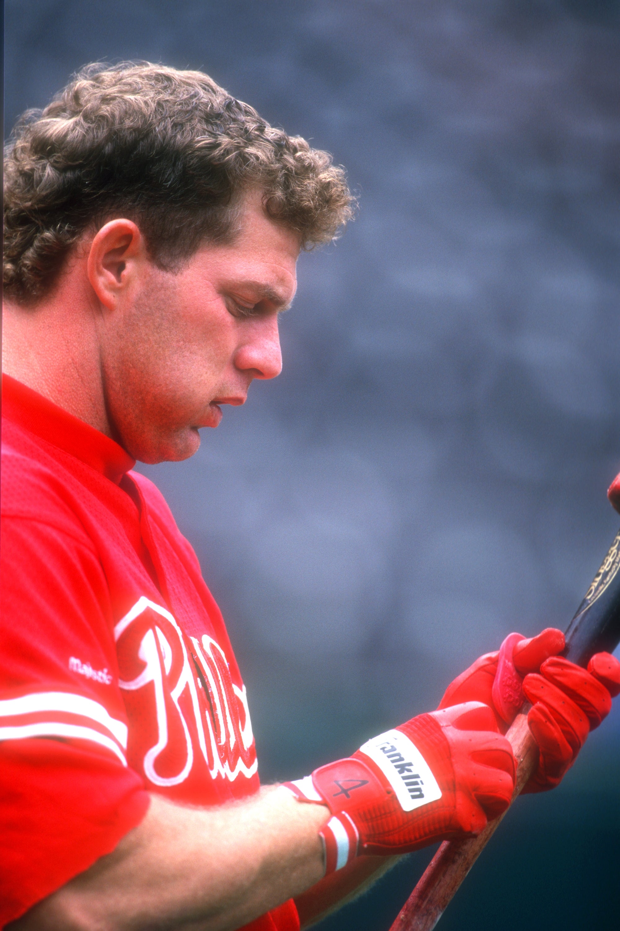 Baseball subordinate    successful  uniform, holding a bat, looks downward with focus