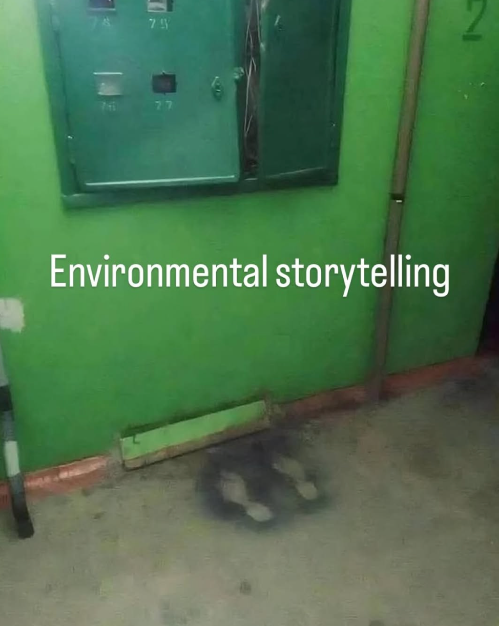 A wall with an open electrical panel and two soot marks below, captioned "Environmental storytelling."
