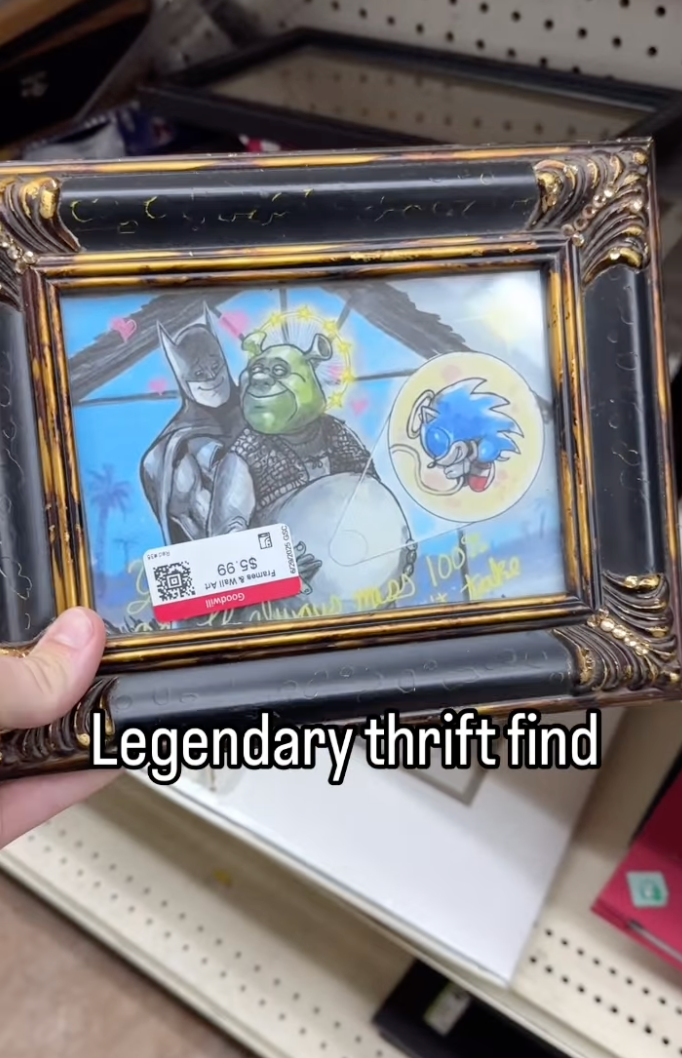 A framed artwork shows Batman hugging Shrek with Sonic in the background. A hand holds the frame in a store with the caption "Legendary thrift find."
