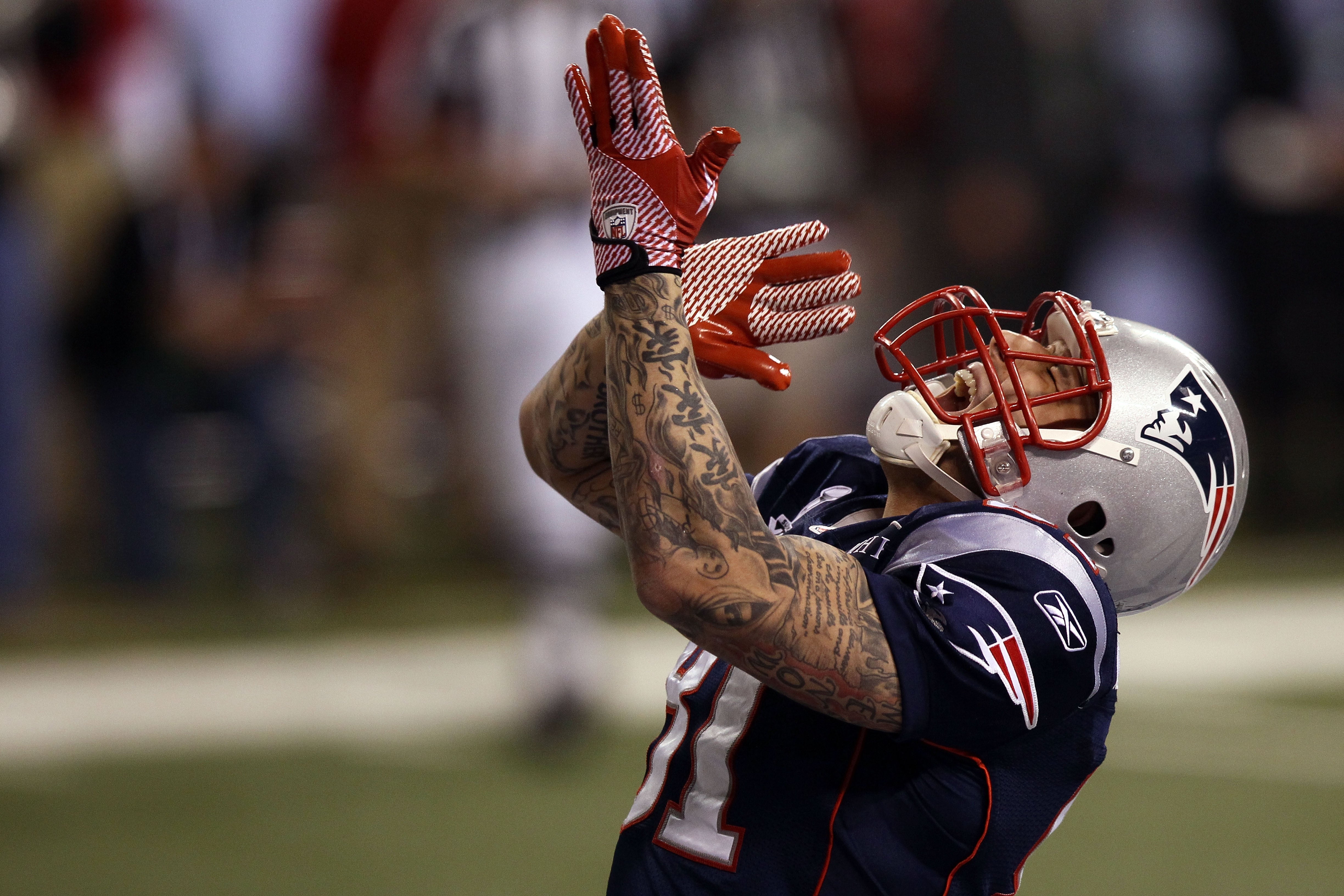 Football player, successful  azygous   with tattoos and gloves, looks upwards during a game