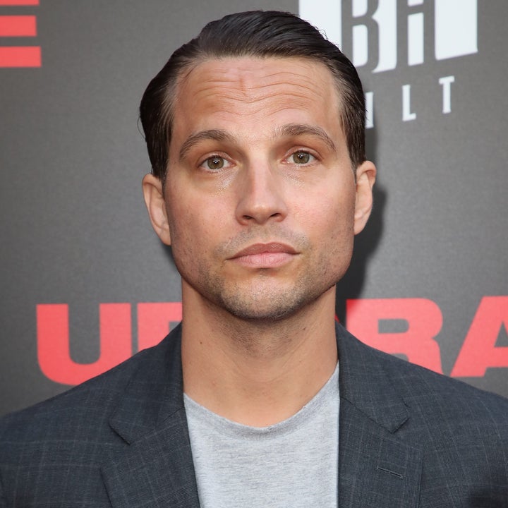 Pessoa com paletó xadrez e camiseta cinza em um evento de celebridades