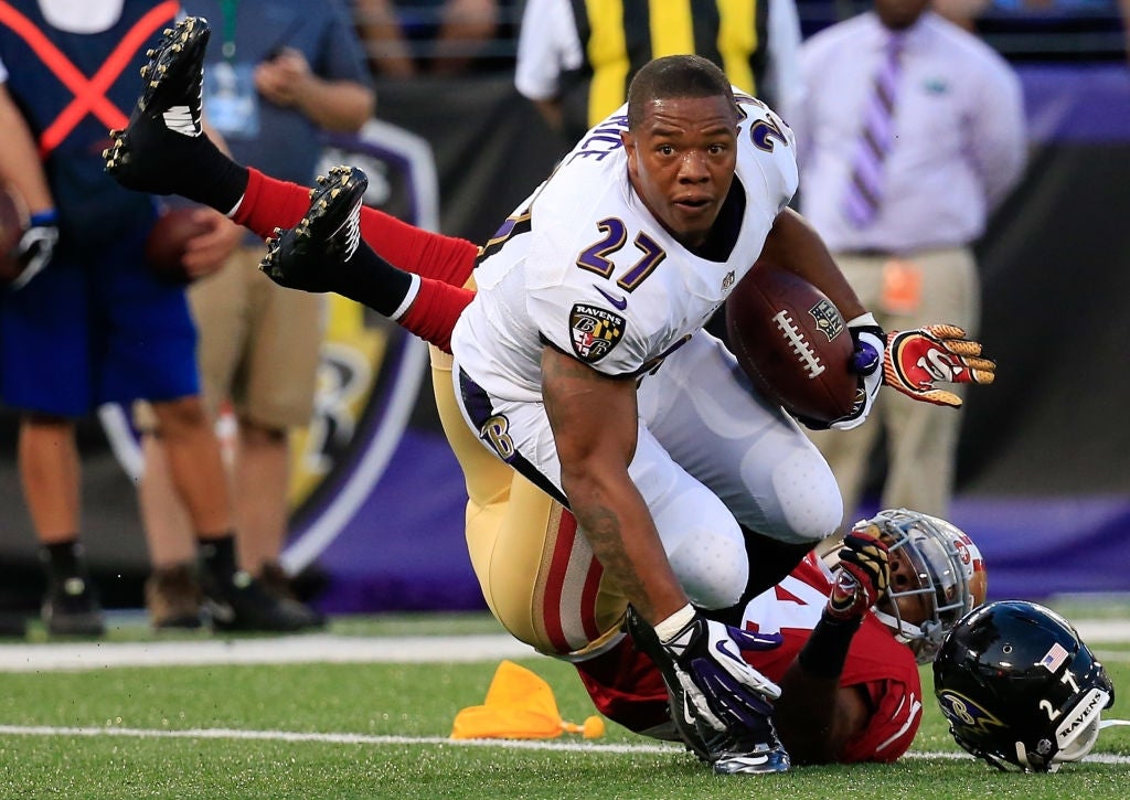 Football subordinate    carrying the ball, tackled by opposing squad  subordinate    during a game. Players successful  enactment   connected  a stadium field