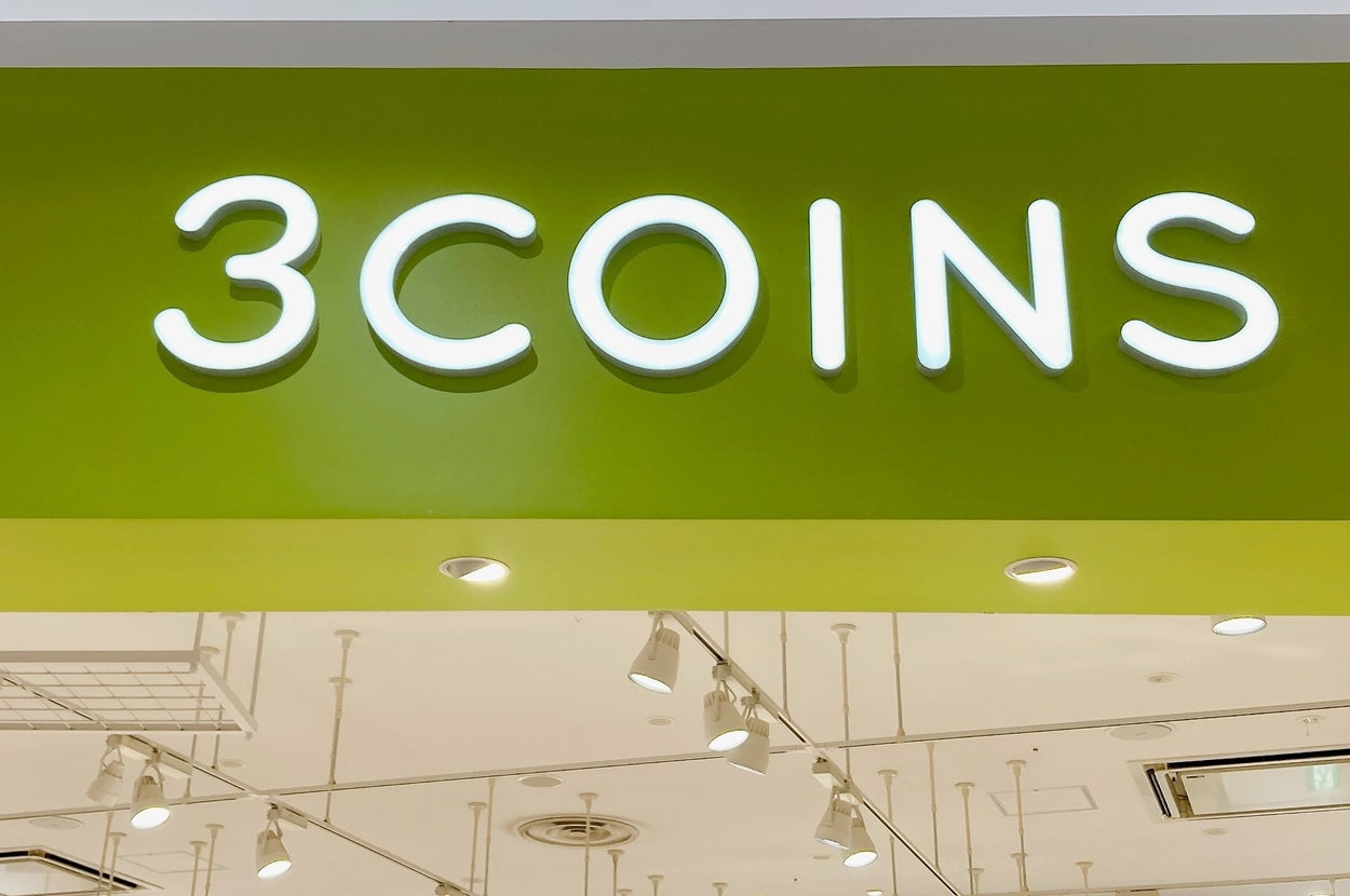 3COINSの店舗入り口の看板。明るい店内と「300円であなたのちょうどいいを」などの広告文が見える。