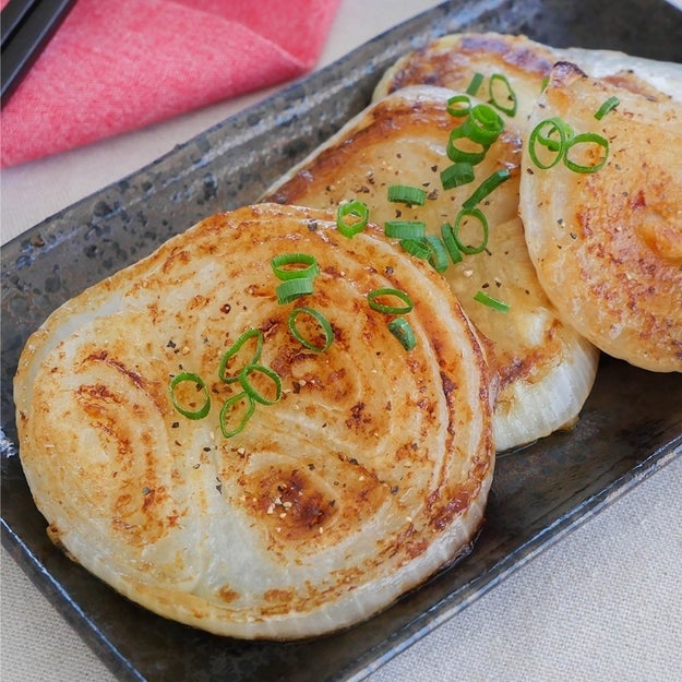 鉄板の上に並んだ焼き回鍋肉風味の玉ねぎパンケーキ、青ネギがトッピングされています。