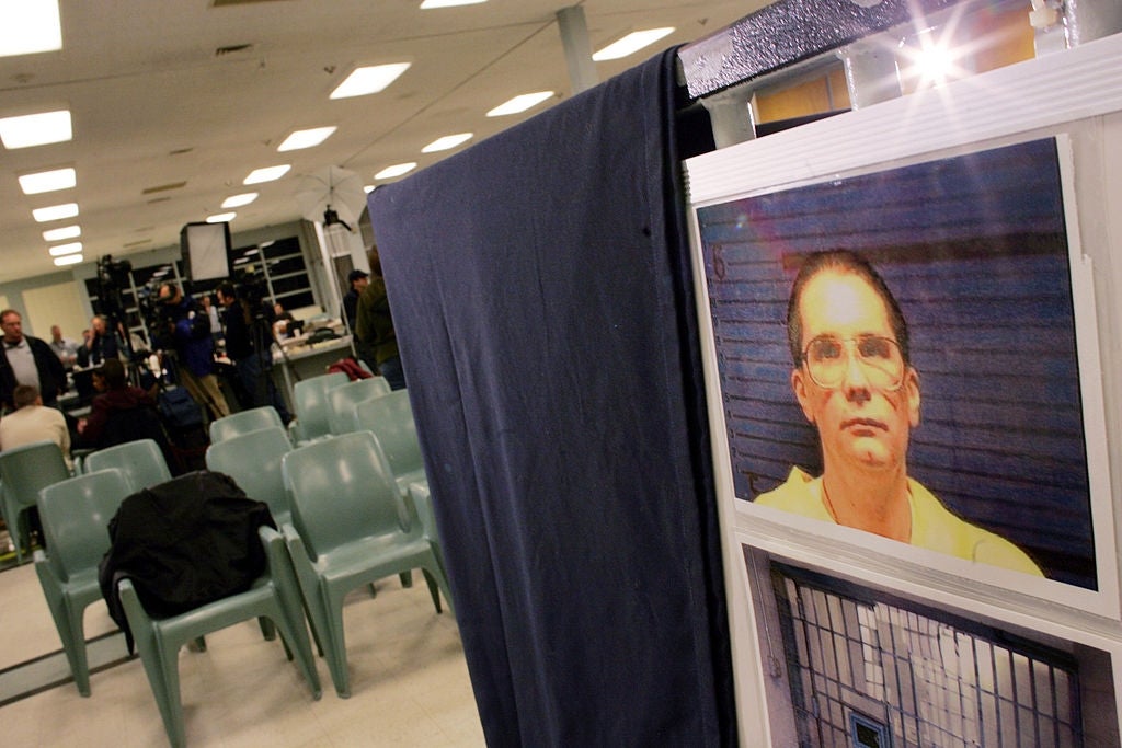 A photograph  of a antheral   displayed connected  a surface  successful  an bare  country   with rows of unoccupied chairs and a fewer  radical   successful  the background