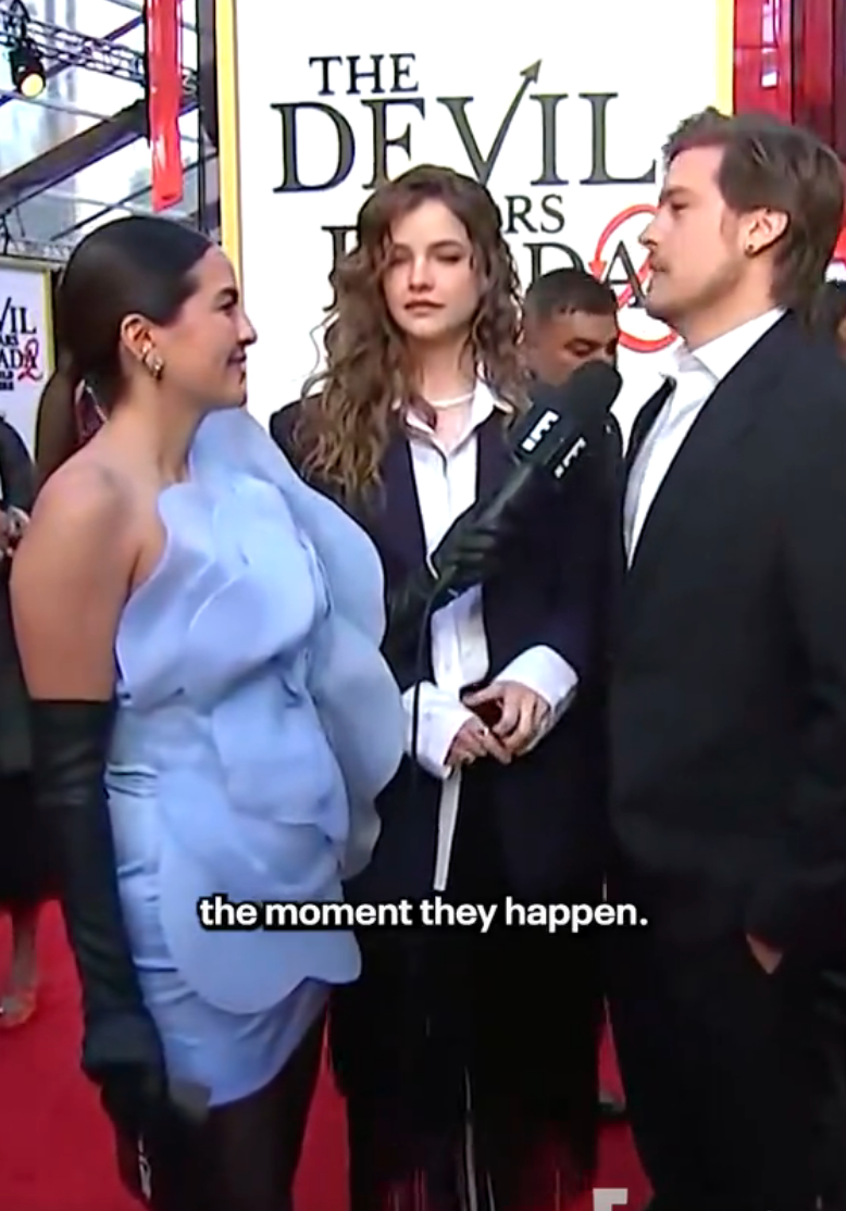 Three radical   connected  a reddish  carpet; 1  successful  a airy  frilly dress, different  successful  a acheronian  overgarment   and achromatic  shirt, and the 3rd  successful  a suit   with a microphone