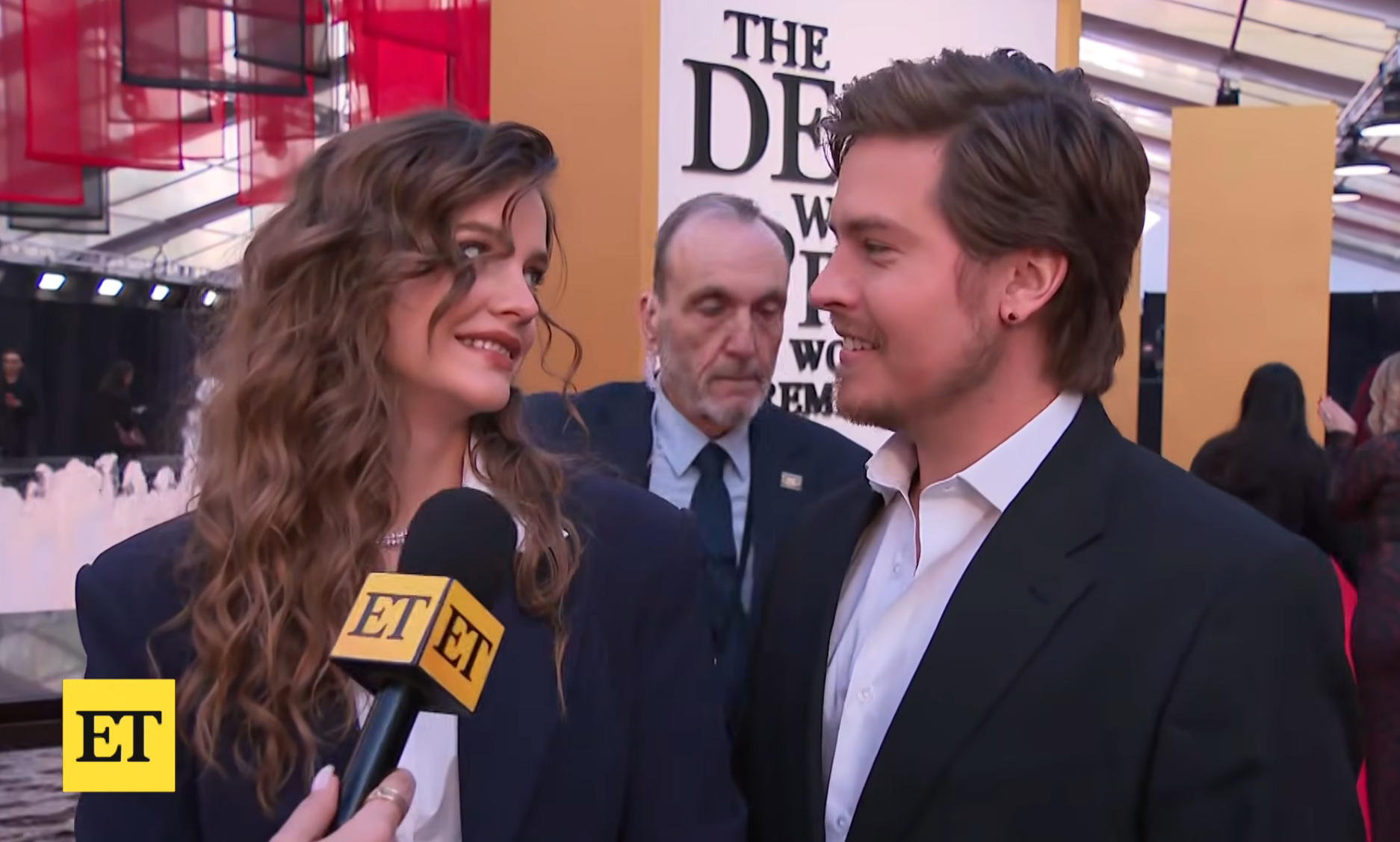 Two radical   smiling astatine  each   different   during a reddish  carpet lawsuit   interview. The pistillate   wears a blazer, the antheral   wears a suit