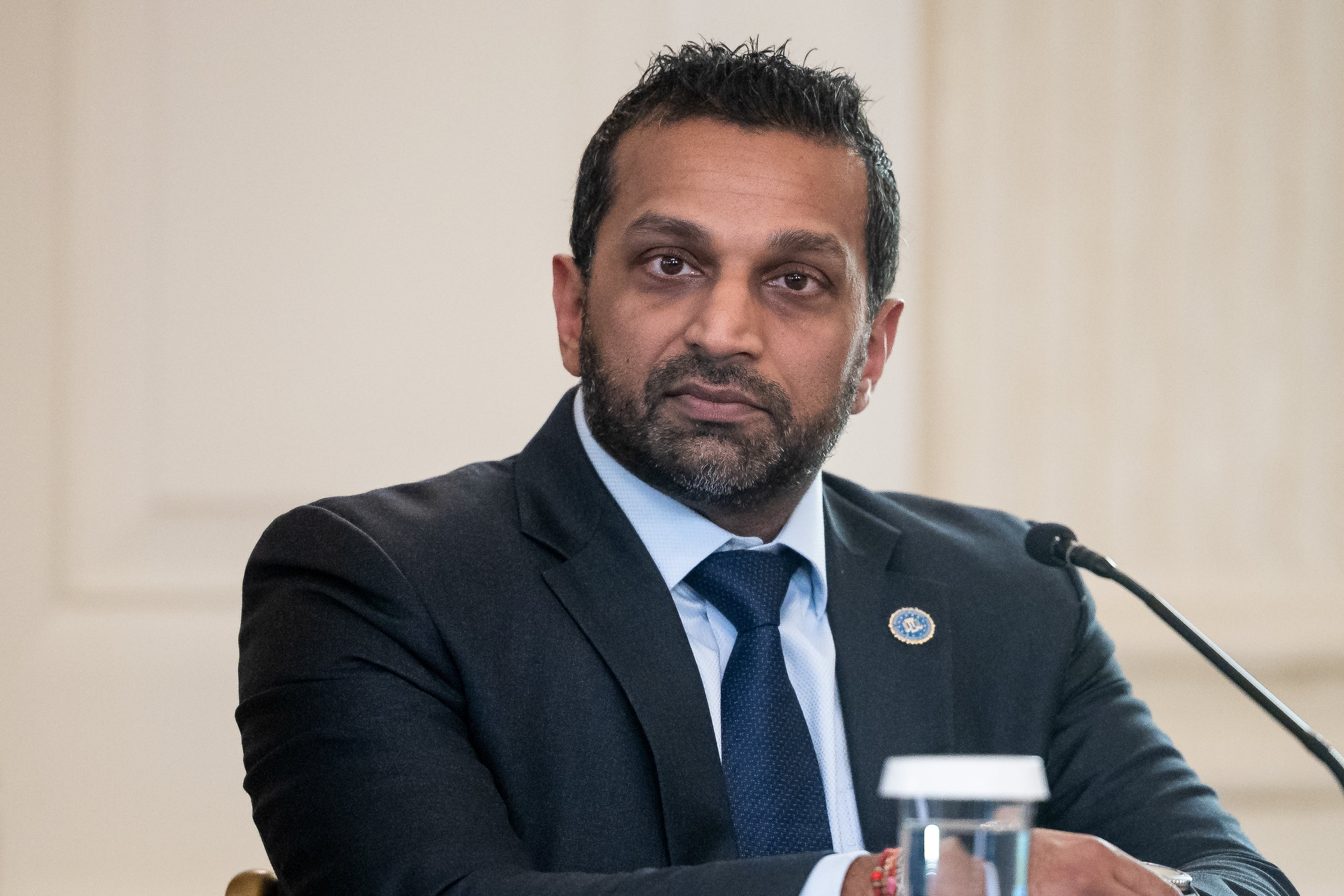 A idiosyncratic   successful  a suit   and necktie  speaks astatine  a podium during a ceremonial  event, appearing engaged and focused