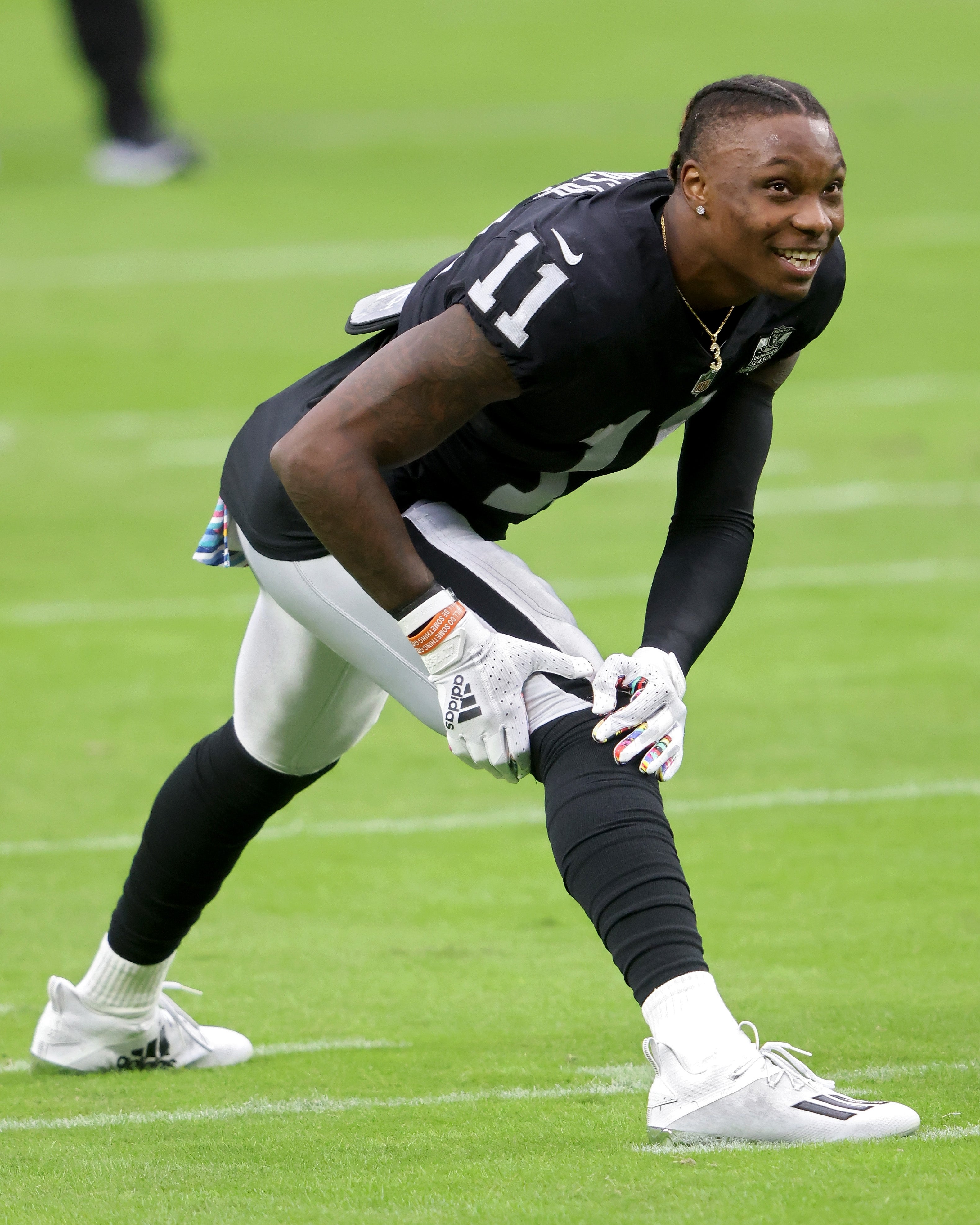 Football subordinate    stretches connected  the field, wearing a achromatic  jersey with the fig   11 and achromatic  pants, smiling earlier  a game