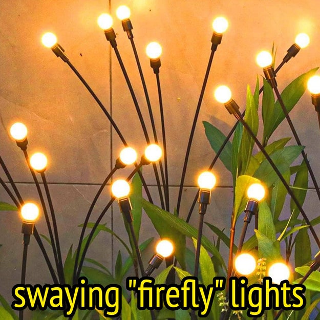 Fairy lights on flexible stems are artistically arranged among green plants, creating a cozy and elegant ambiance suitable for decorating spaces