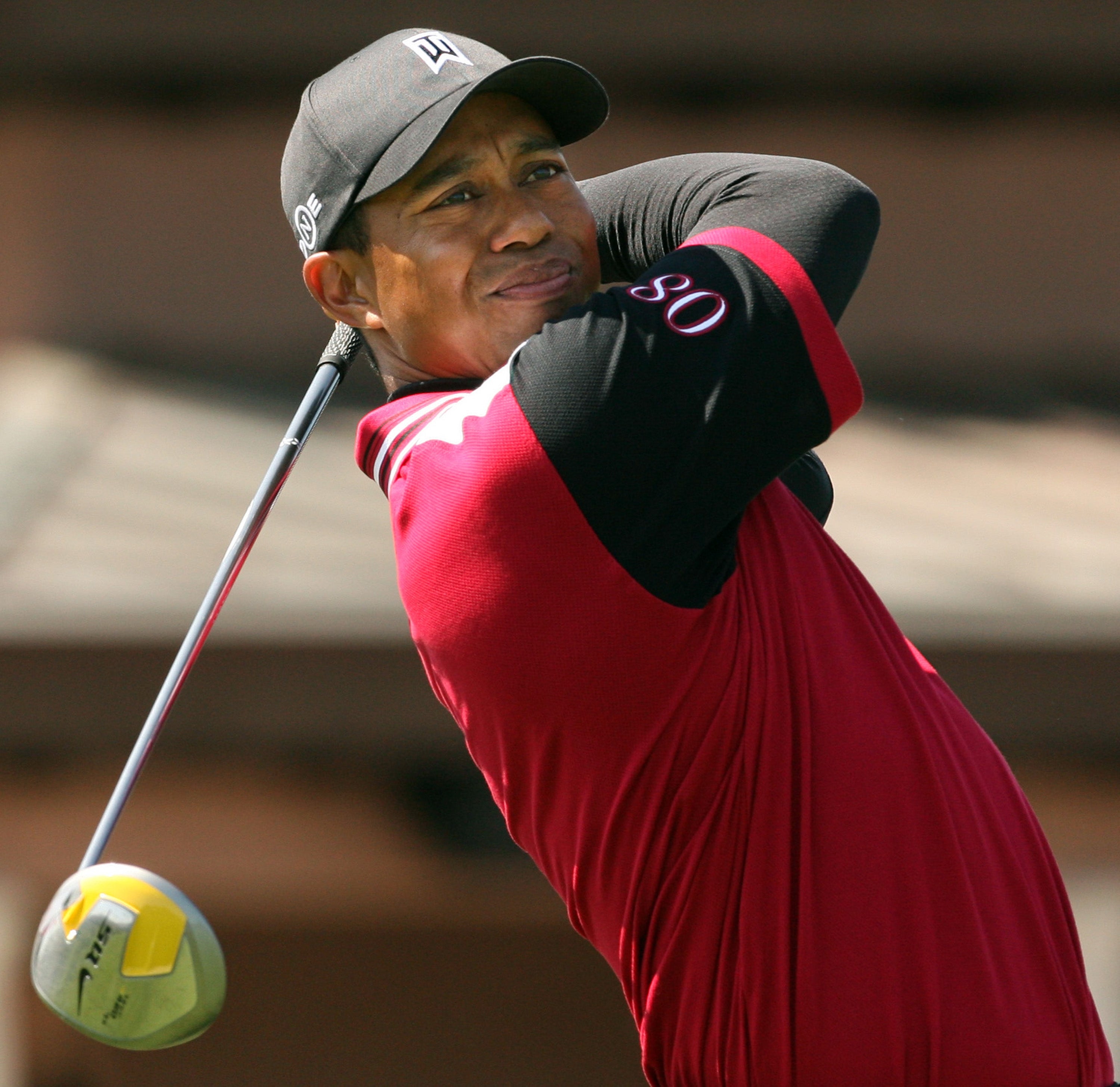 Golfer swinging a nine  during a tournament, wearing a headdress  and sporty outfit