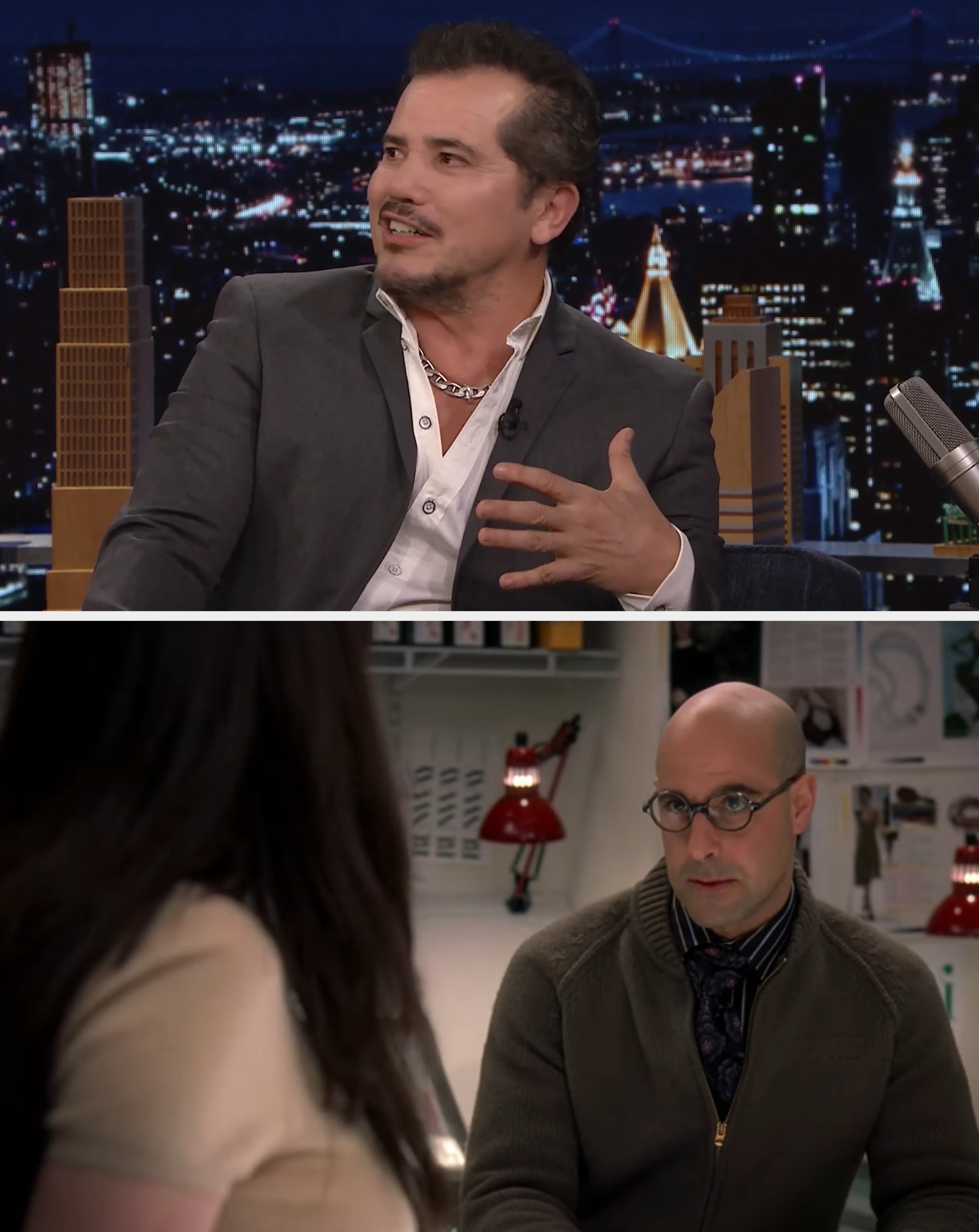 A idiosyncratic   successful  a suit   and open-collared garment  gestures portion    seated connected  a late-night speech   amusement   acceptable   with a cityscape backdrop