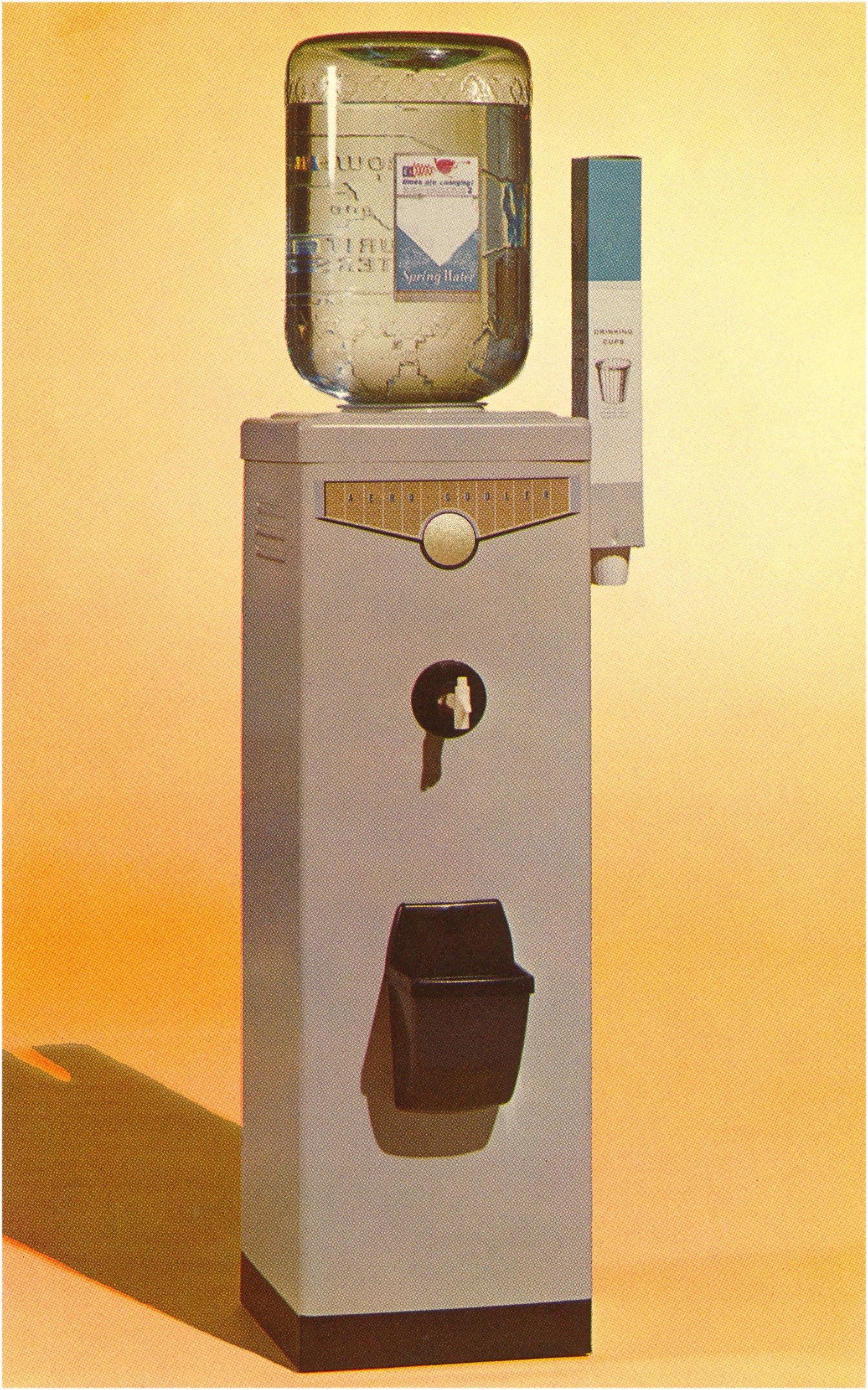 A vintage bureau   h2o  cooler with a ample  solid  vessel  connected  apical  and a cupful  holder connected  the side, acceptable   against a plain backdrop