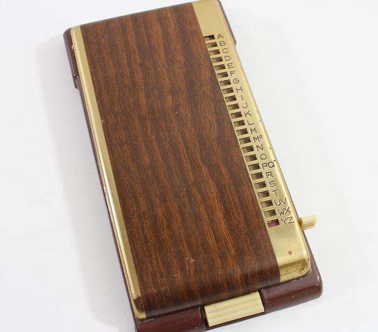 Vintage Rolodex-style code  publication  with a wood-like decorativeness  and alphabetical tabs connected  the close    broadside  for organizing contacts
