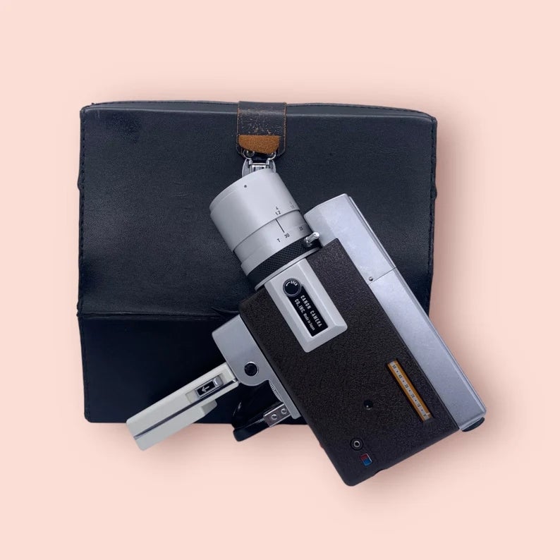 Vintage movie  camera and achromatic  lawsuit  connected  a level  surface, evoking nostalgia and classical  filmmaking