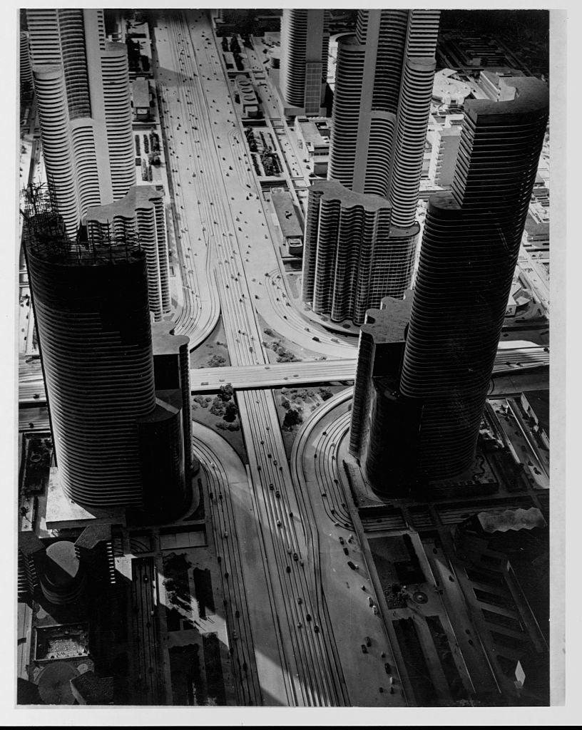 Aerial presumption    of a futuristic cityscape with tall, cylindrical buildings and wide   roads, showcasing modern   municipality  architecture