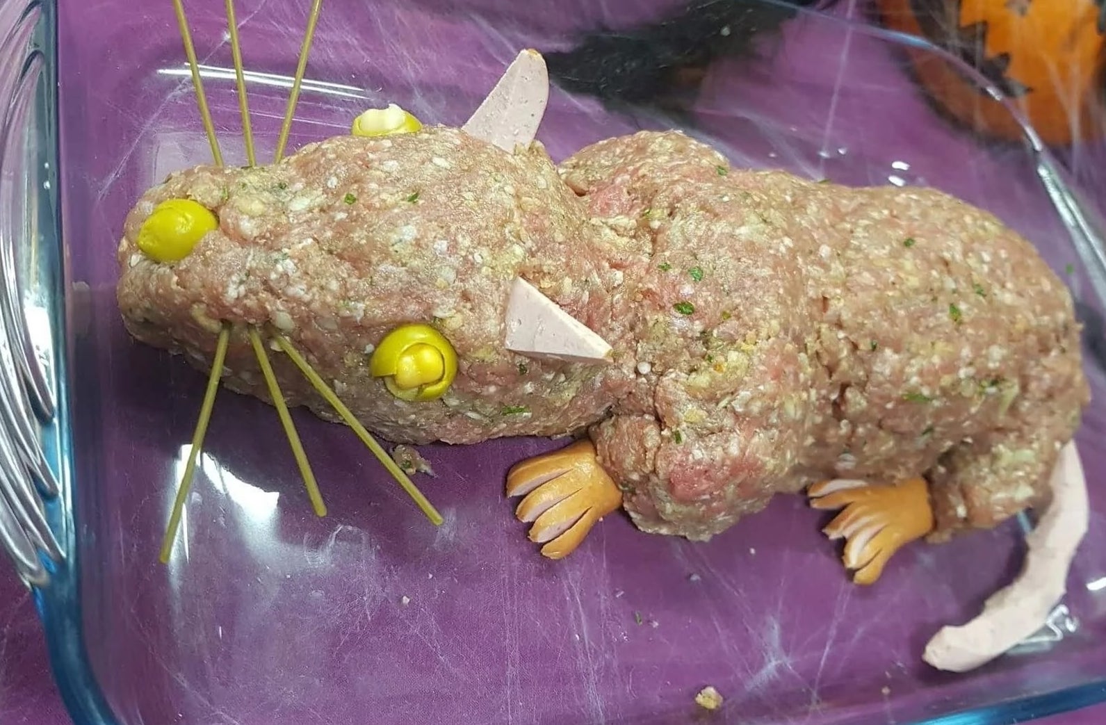 Daging giling mentah berbentuk tikus, dengan kumis spageti, mata sayur, kaki sosis, dan telinga & ekor yang terbuat dari irisan daging