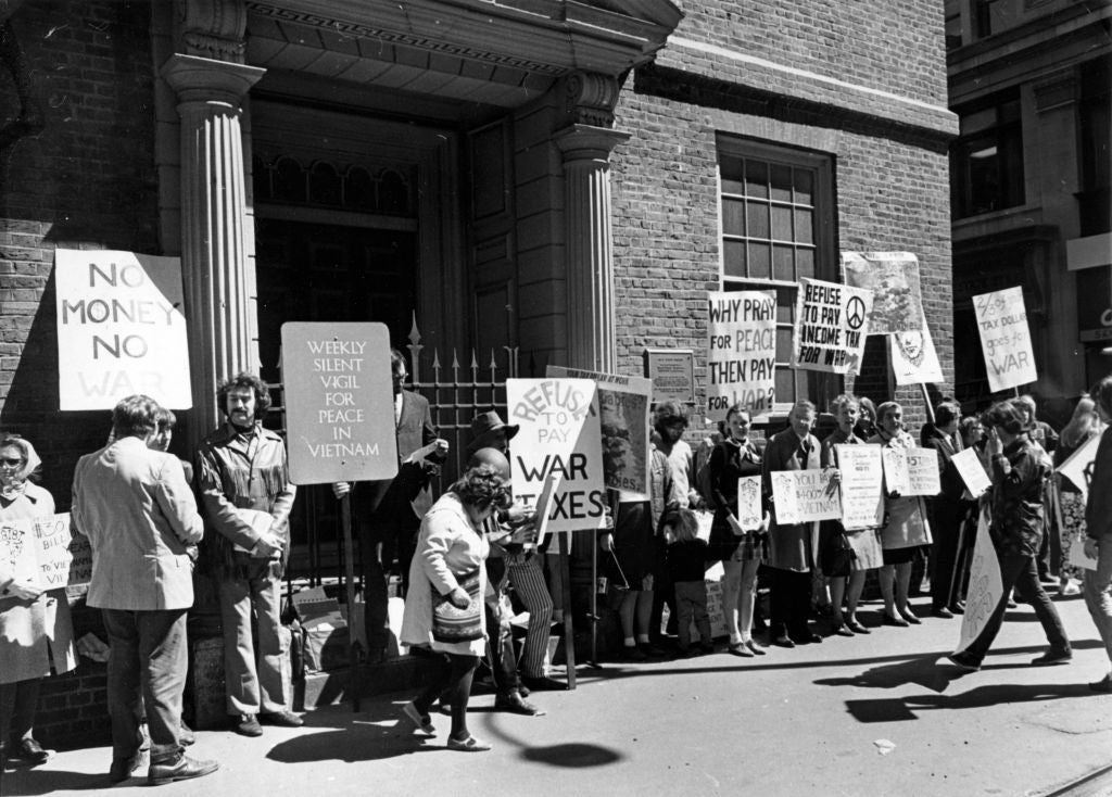 Protesters extracurricular  a gathering  clasp  signs opposing warfare  taxes and advocating for bid    successful  Vietnam