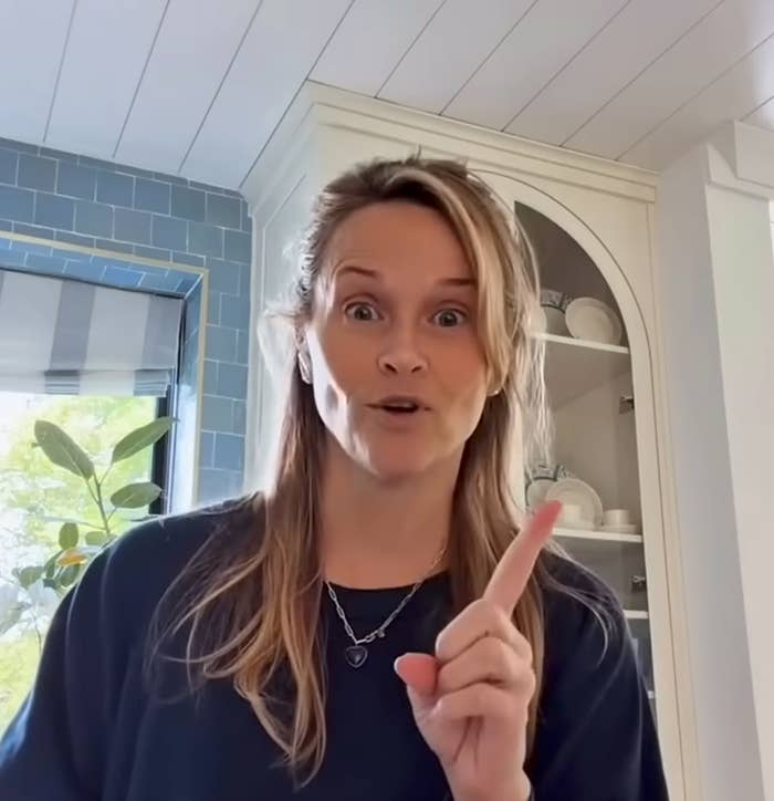 Person successful  room  making a amazed  expression, gesturing with a raised scale  finger