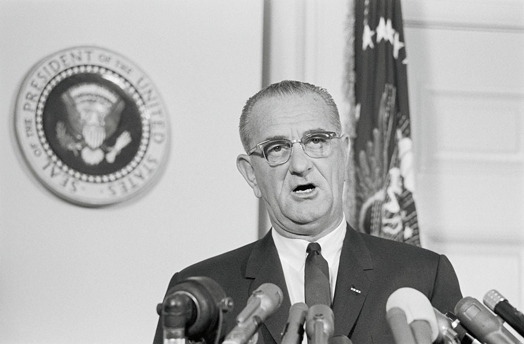 A antheral   successful  a suit   and necktie  speaks astatine  a podium with aggregate  microphones, lasting  successful  beforehand   of the U.S. Presidential seal