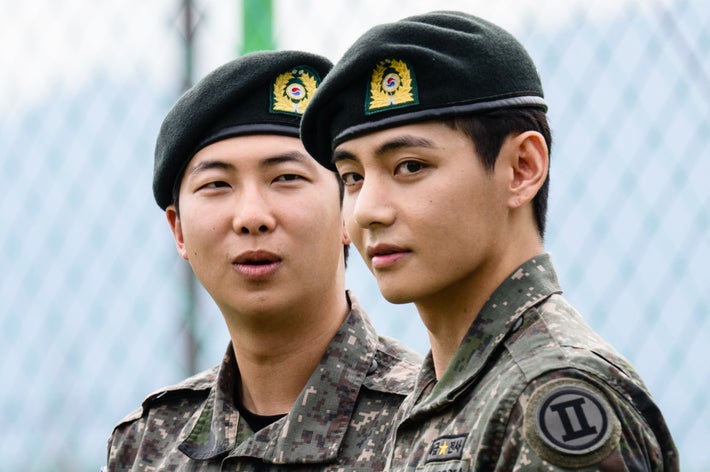 韓国の兵役期間を終え、除隊日に撮影されたBTSのVさん（右）とRMさん（左）/ ANTHONY WALLACE / AFP＝時事