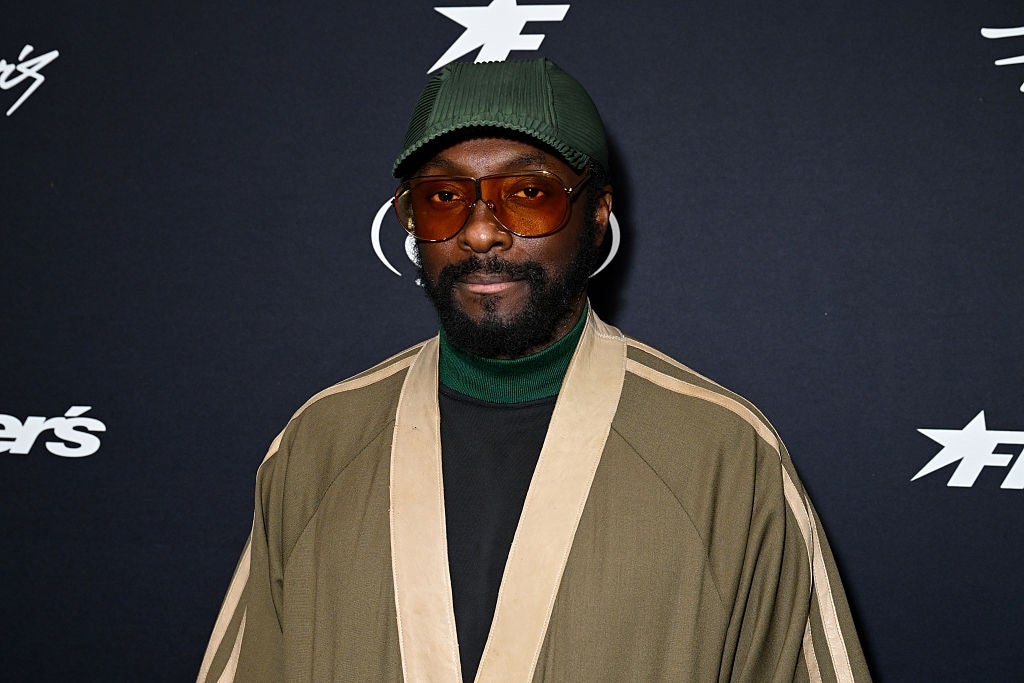 A idiosyncratic   wearing a stylish, oversized outfit with a headdress  and tinted glasses astatine  a personage  event