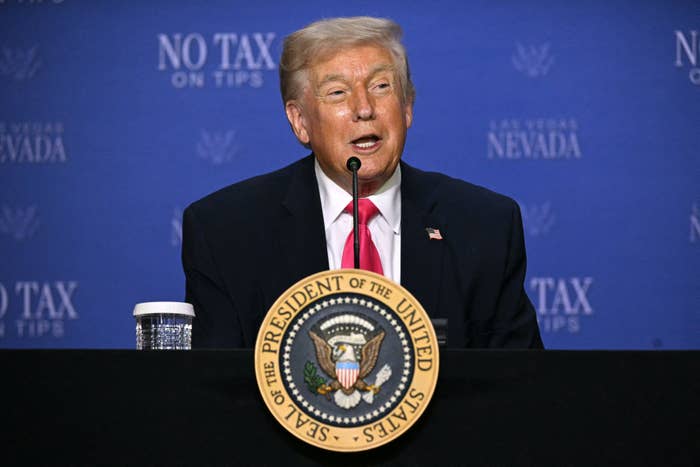 Donald Trump speaks astatine  a podium labeled with a authorities  seal, successful  beforehand   of a backdrop with "No Tax connected  Tips" and "Las Vegas Nevada" printed