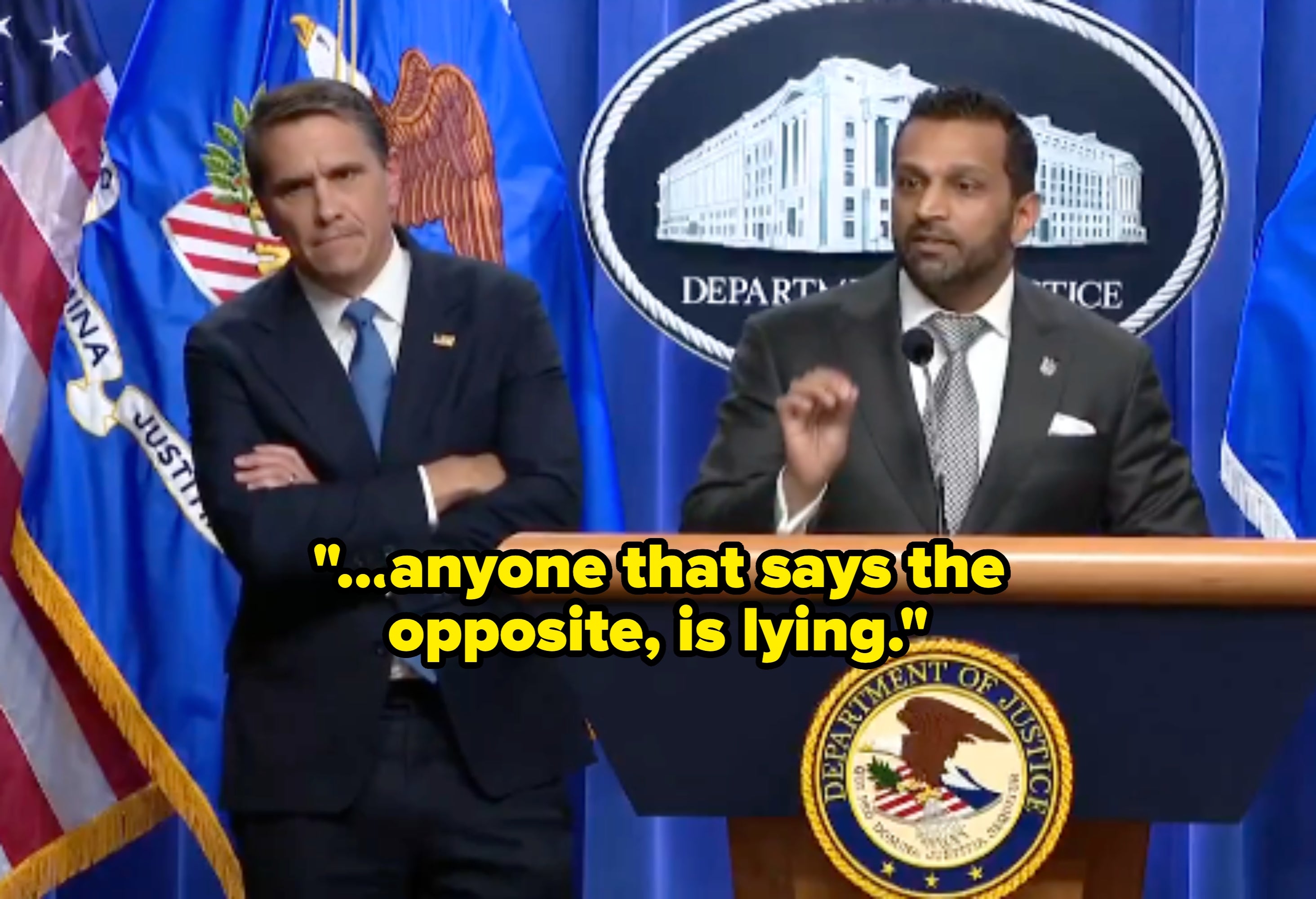 Two officials successful  suits talk  astatine  a Department of Justice podium