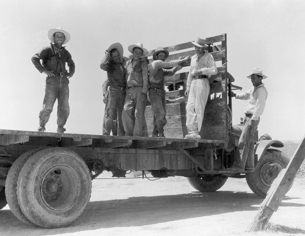 A radical  of six men successful  enactment    attire with hats basal   and airs  connected  the flatbed of a truck