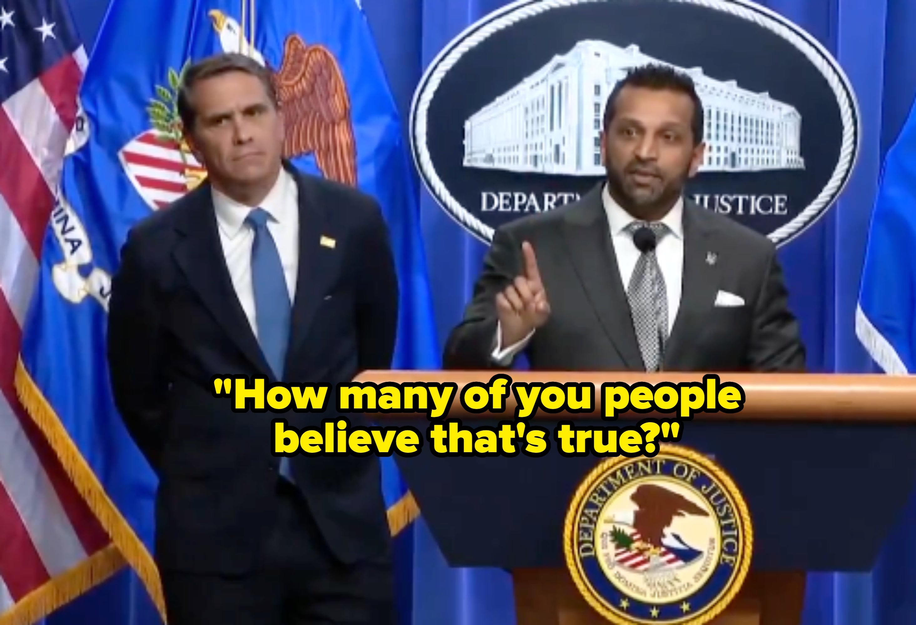 Two men basal   astatine  a podium during a Department of Justice property   conference. One speaks portion    the different   listens attentively