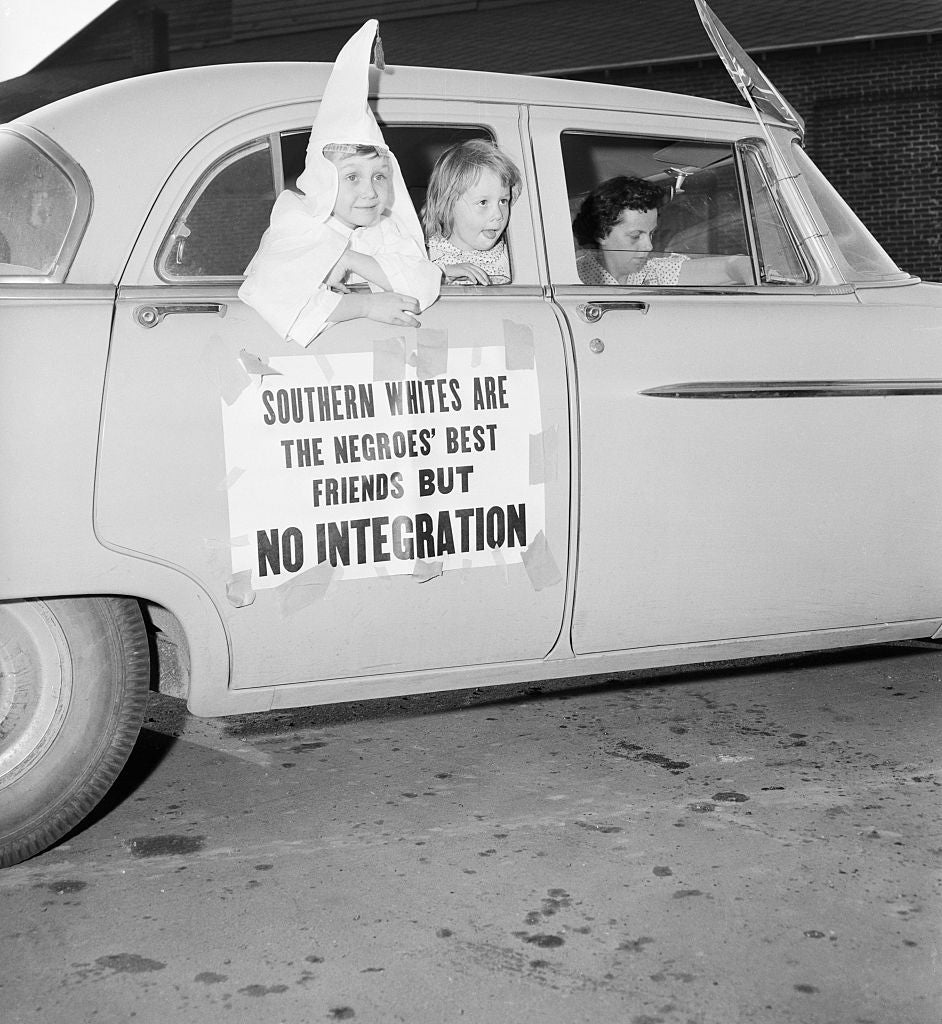 Child successful  KKK outfit leans retired  of car   model   displaying a motion   that reads, "Southern whites are the Negroes' champion  friends but nary  integration."