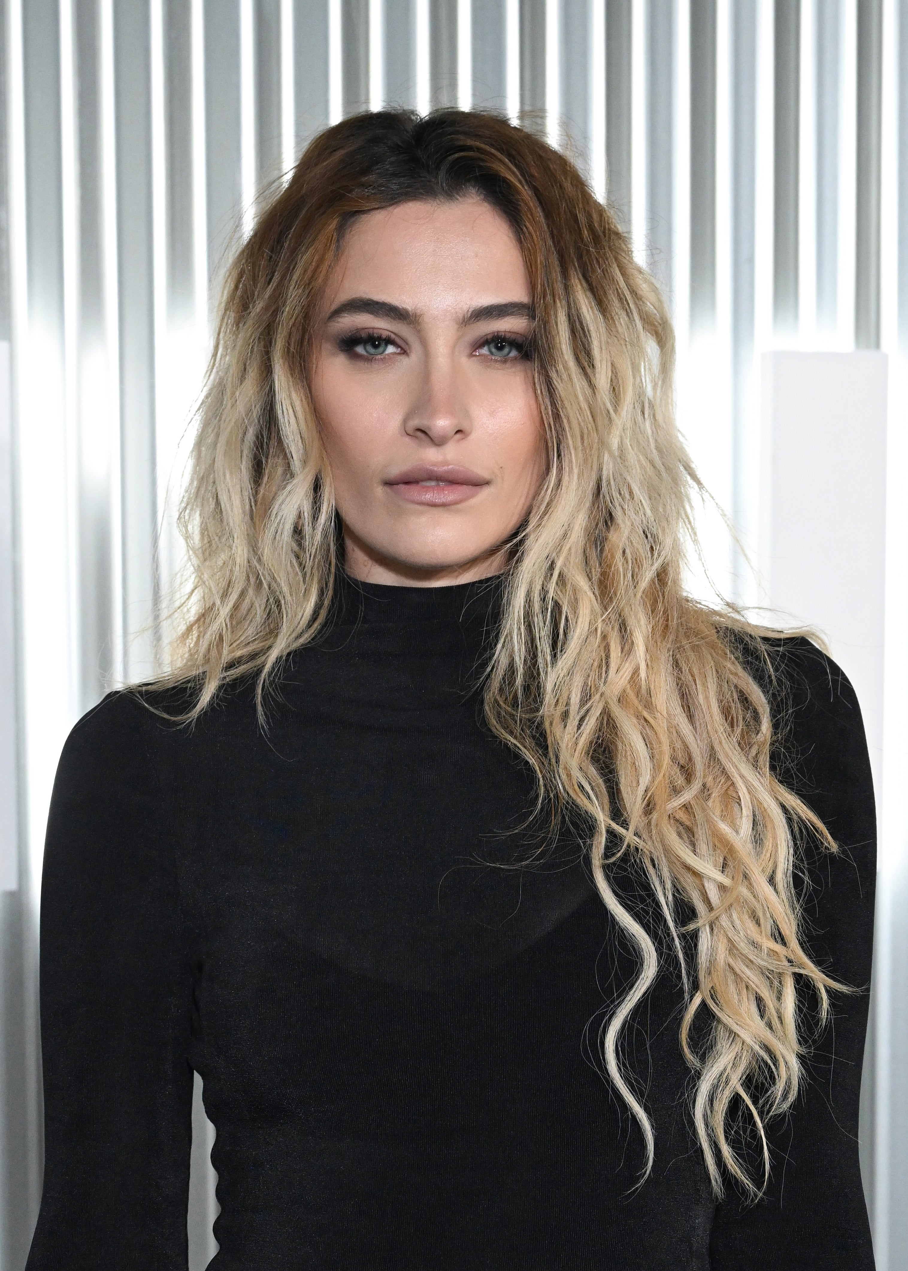 Person with agelong  wavy hairsbreadth  and acheronian  eyeliner wearing a sleek achromatic  turtleneck successful  a modern   setting