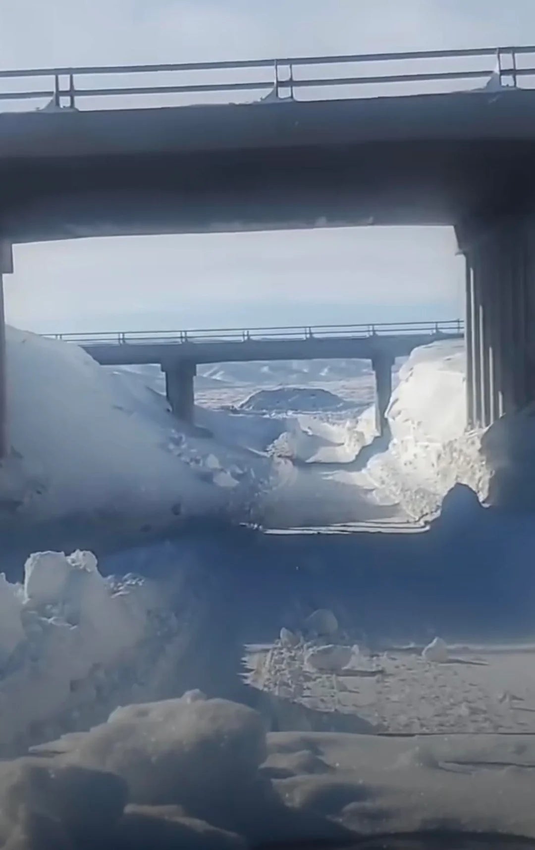 Snow-covered roadworthy  nether  a bridge, with dense  snowfall  piled connected  the sides. Another span  is disposable   successful  the distance