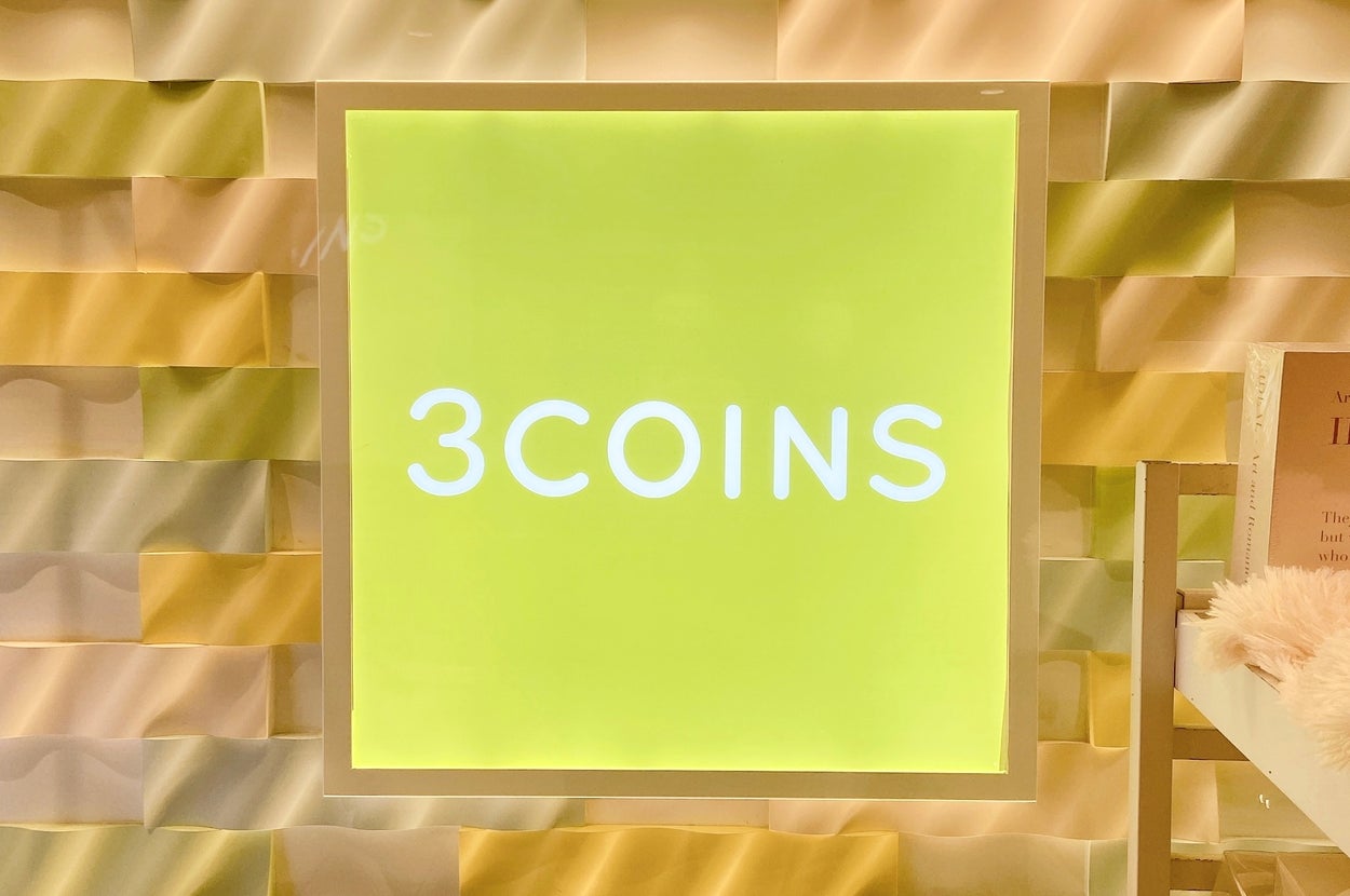 「3COINS」の看板が飾られた壁の一部が写っています。