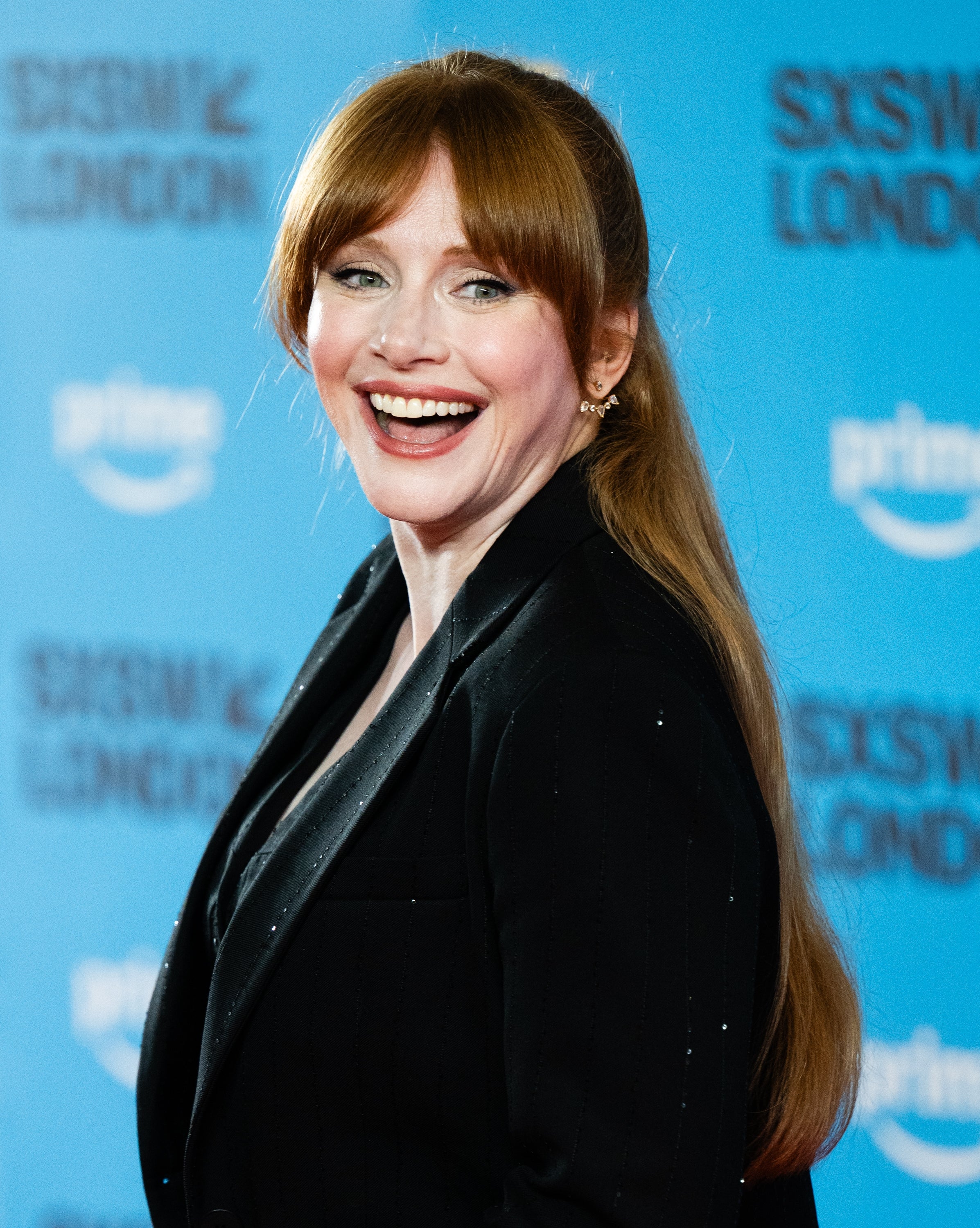Bryce Dallas Howard with agelong  hairsbreadth  smiles successful  a blazer astatine  a SXSW London event